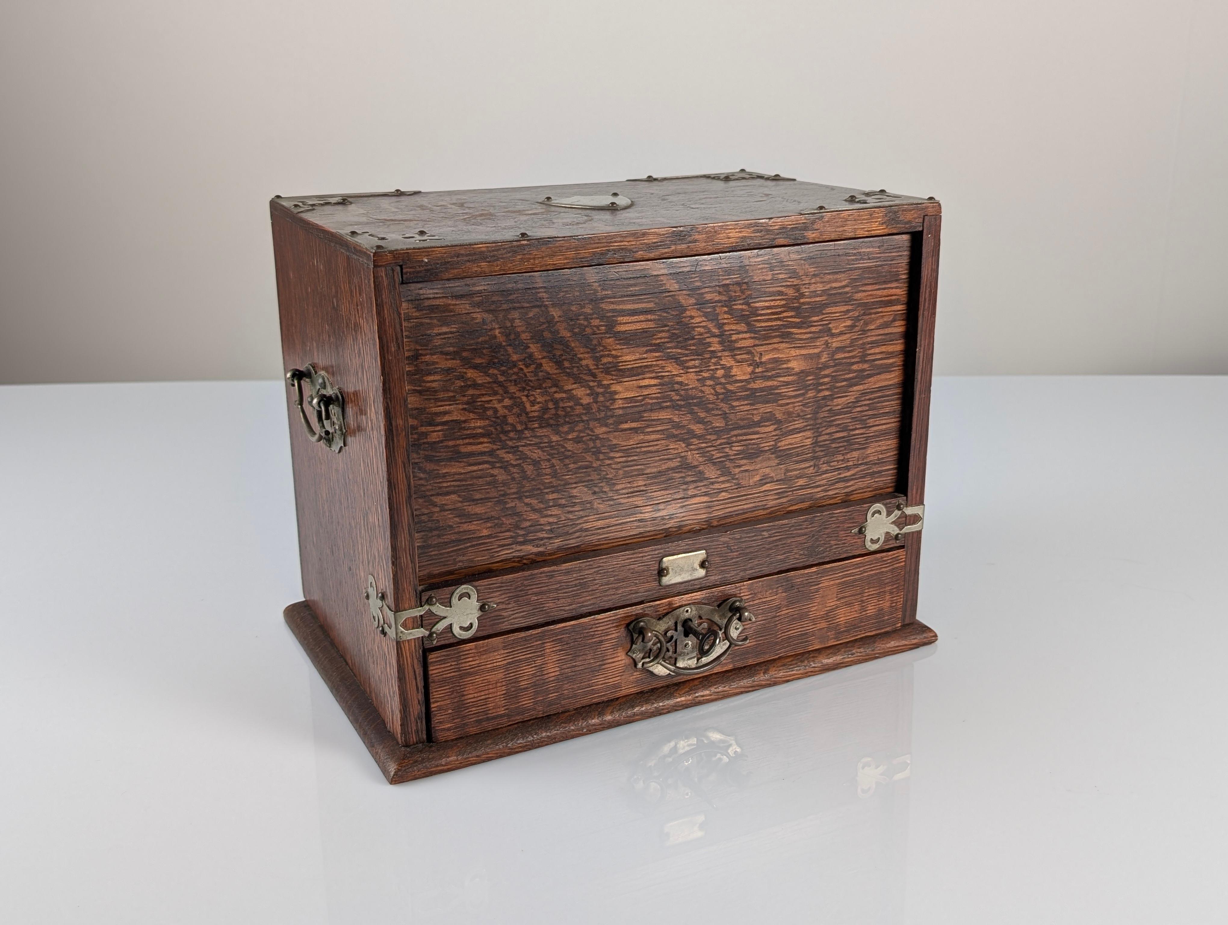 Antique Victorian desktop writing cabinet made in 19th-century England, crafted in dark oak wood with well-defined grain and original period hardware in silver-toned metal. This is a truly unusual model featuring a clever mechanical design: the
