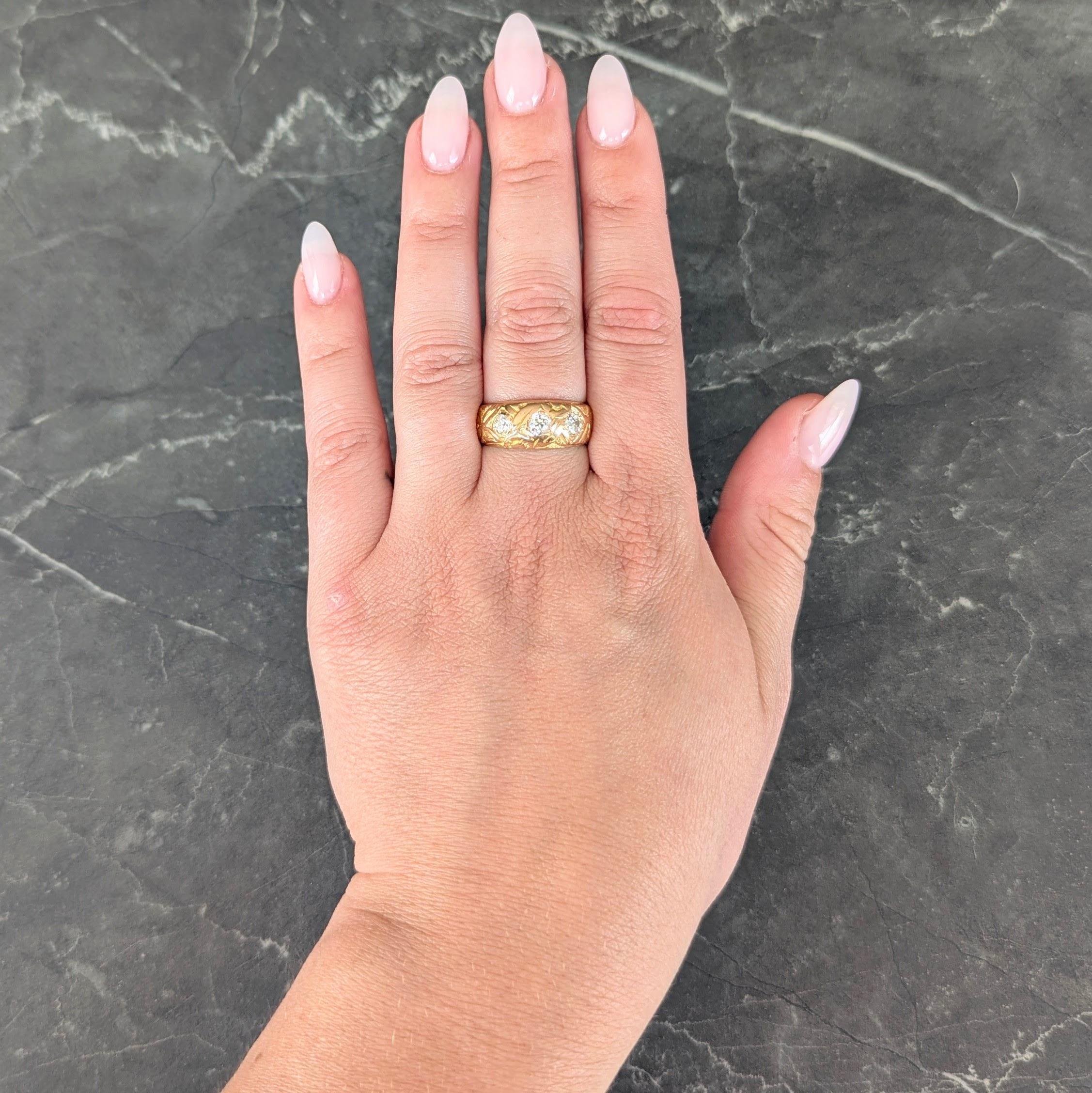 Featuring three old mine cut diamonds flush set east to west
Weighing approximately 0.62 carat total
G/H color with VS2 clarity - with bombé surround
Accented by a deeply grooved orange blossom motif
Stamped for 18 karat gold
Circa: 1890s
Ring size: