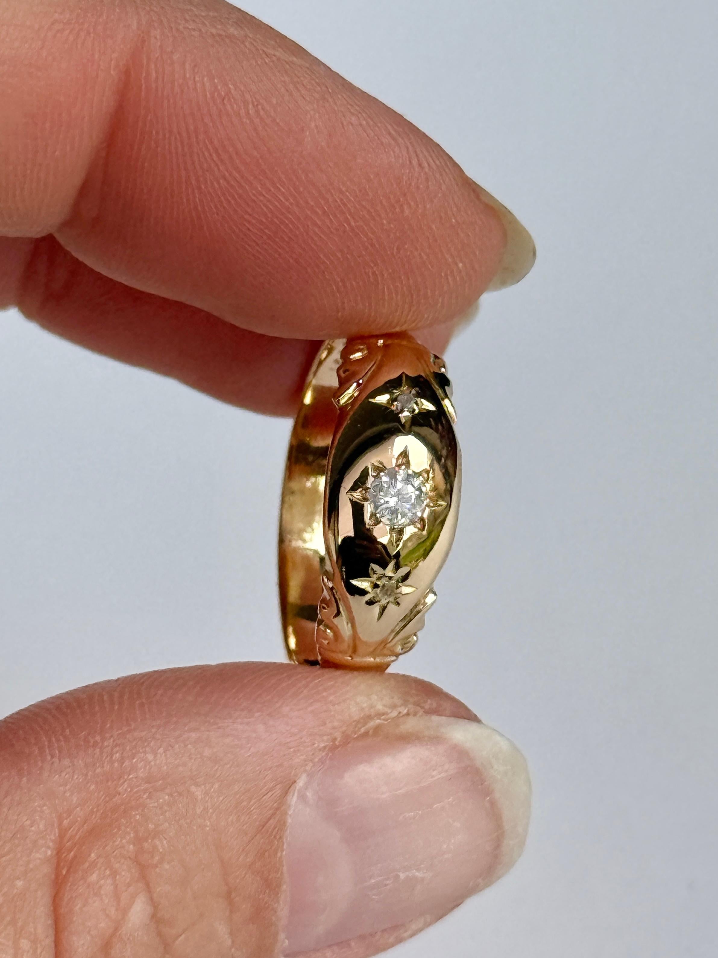This gorgeous 18ct gold band holds three diamonds. The diamond total of this ring is 17 pts. The central diamond measures 15pts. 

Ring Size: P 1/2 or 8 
Band Width: 7.5mm 
Height Off Finger: 1.5mm

Weight: 2.6g