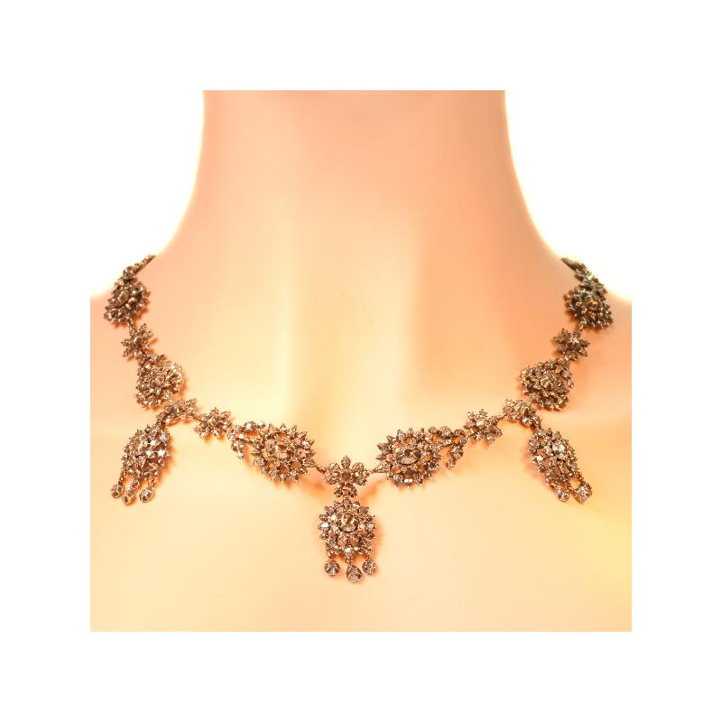 From the first glance it seems obvious that this frivolous red gold backed necklace fits just elegantly around the neck as a garland of six larger flowers alternating with six smaller ones. As three more flower pairs with dangling triplets drape