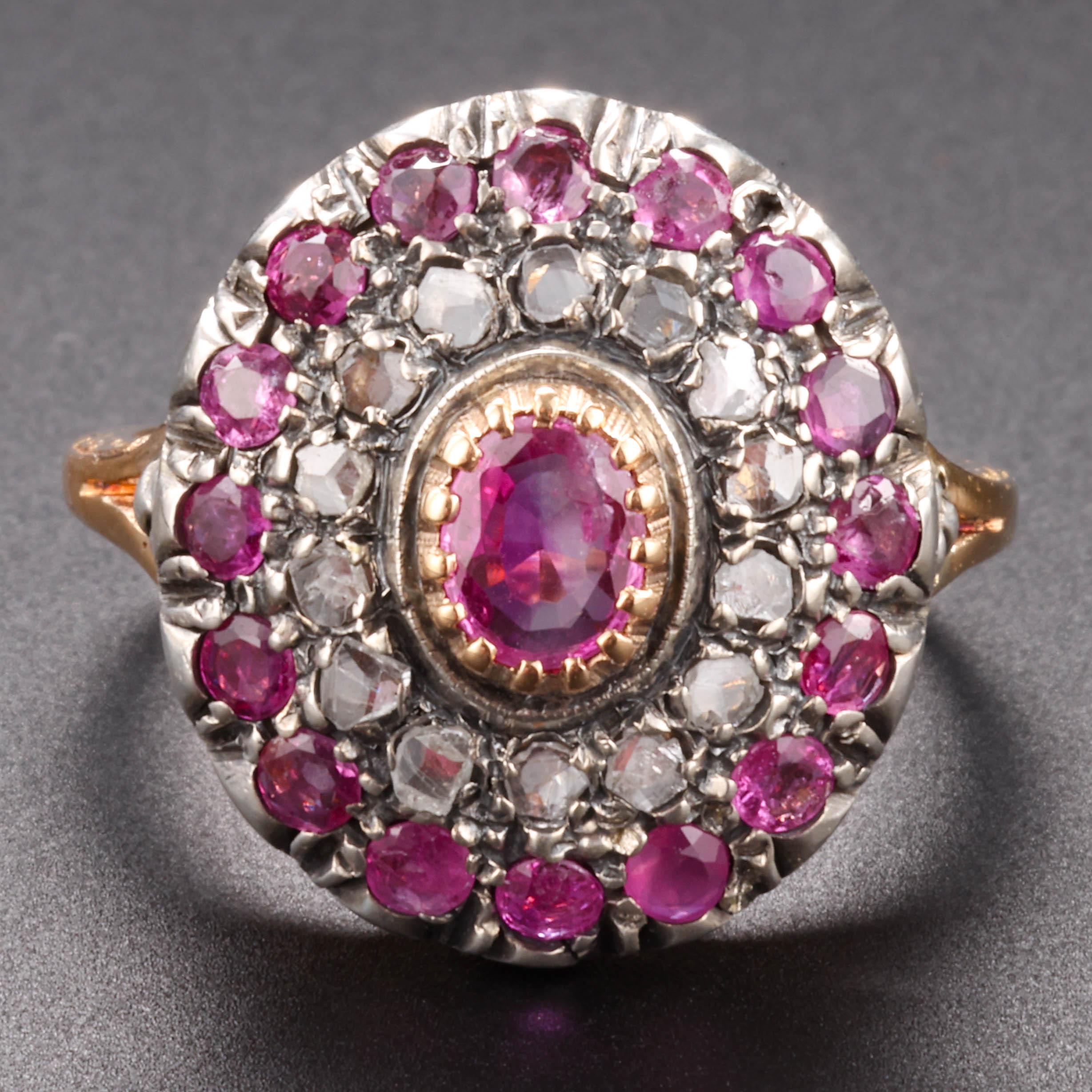 Natural, unheated Burmese pink sapphires and a halo of single-cut diamonds surround a central oval pink sapphire in this late Victorian ring. 

Crafted in 18K gold, the gems are set in silver atop gold, as was common in the era. The ring has strong