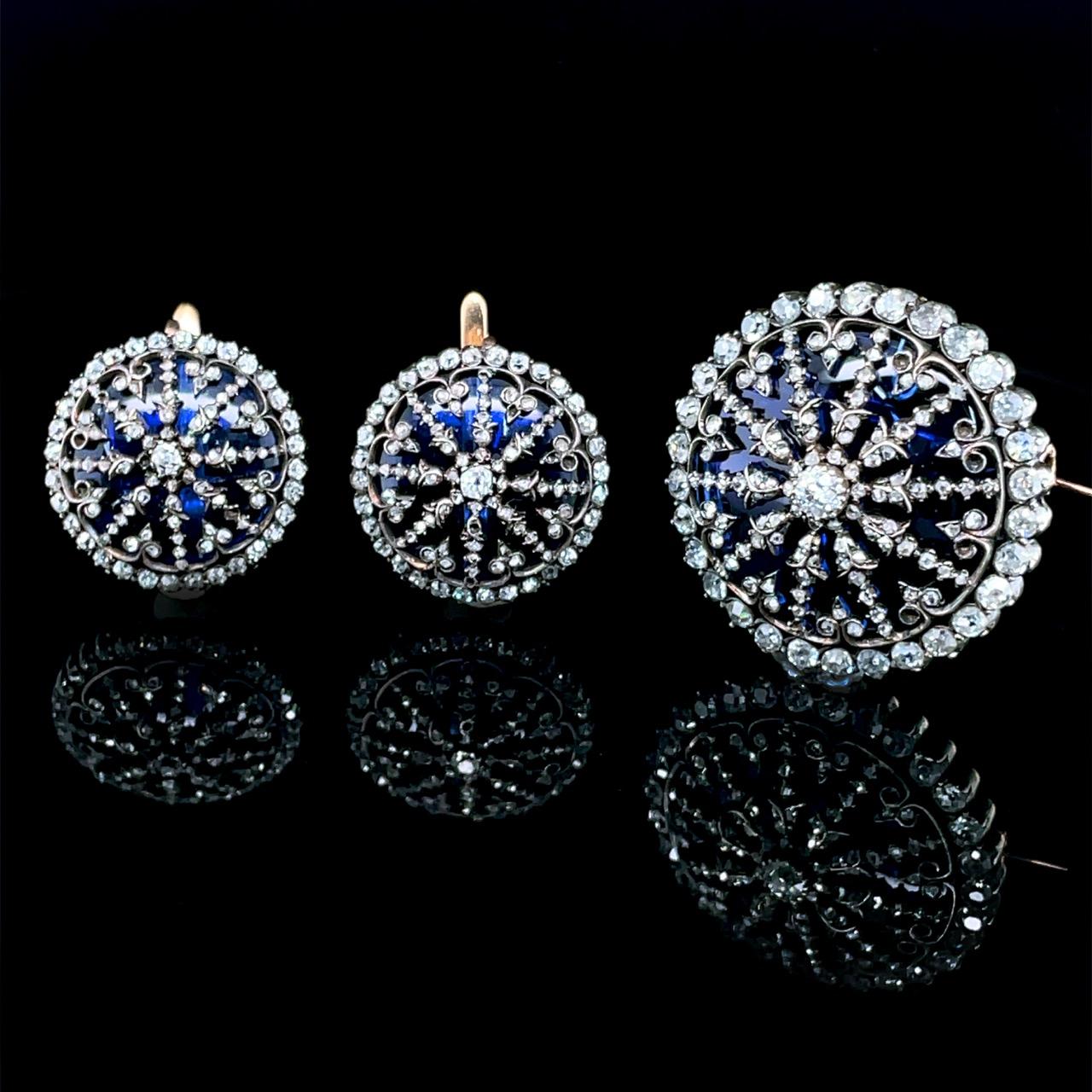 Victorian Diamond and Glas Earrings and Brooch/Pendant Demi Parure, ca. 1880s

A beautiful and very unusual diamond Victorian demi-parure consisting of a pair of earrings and a brooch/pendant. The circular shaped jewels are based on blue-tinted