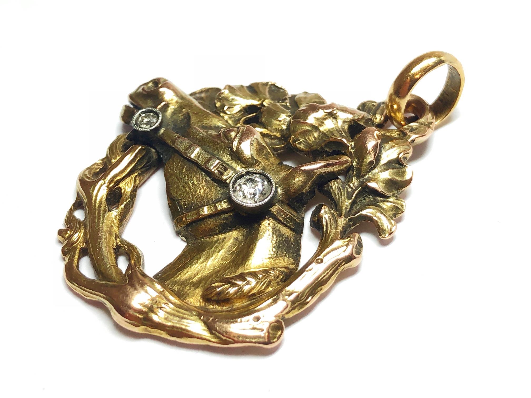 An antique horse pendant, with a horse's head, surrounded by a branch of a Ginkgo Biloba tree, mounted in yellow gold, with two old-cut diamonds set in the bridle, circa 1880.
