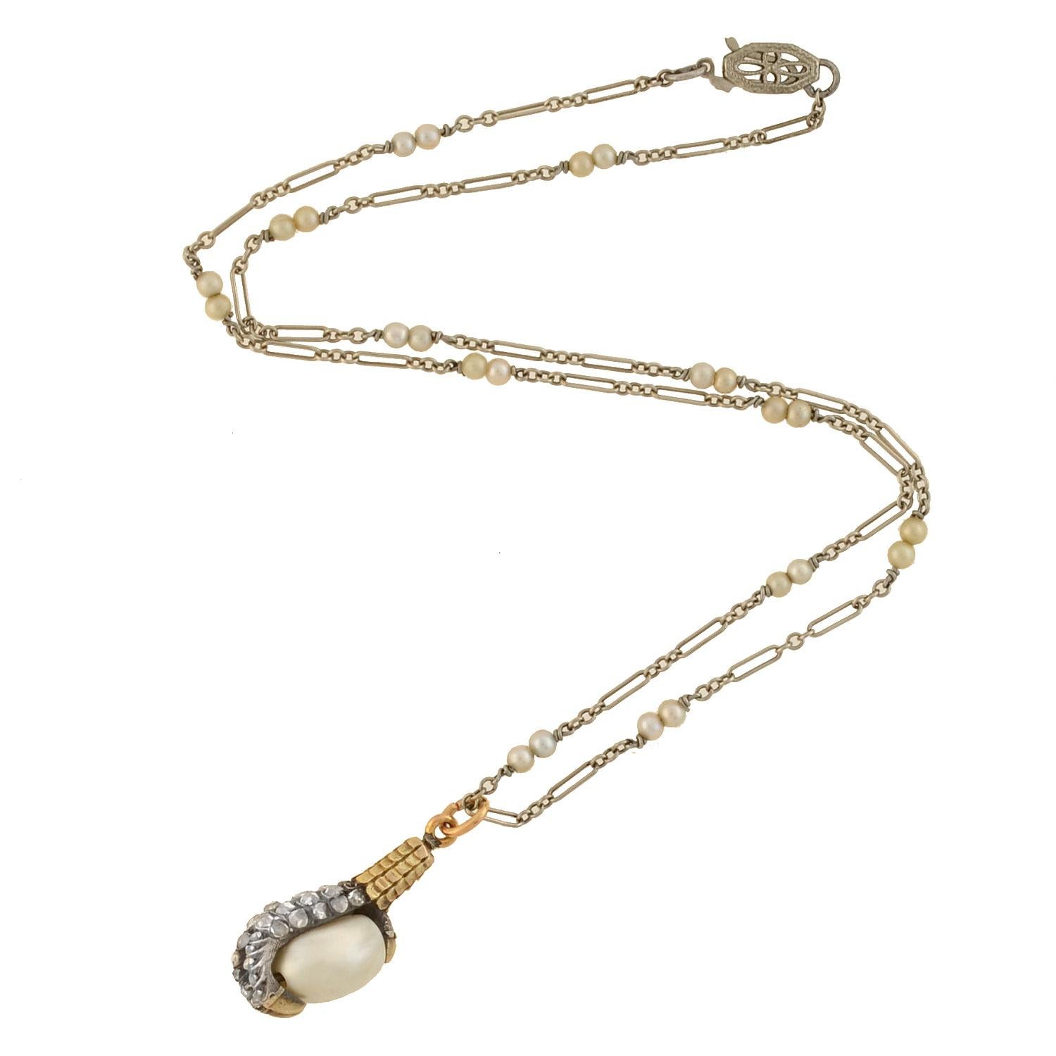 An absolutely stunning pearl claw pendant necklace from the Victorian (ca1880) era! This incredible piece is comprised of an intricate mixed metals diamond and pearl pendant which hangs from a complimentary chain. The pendant is crafted in 18kt gold