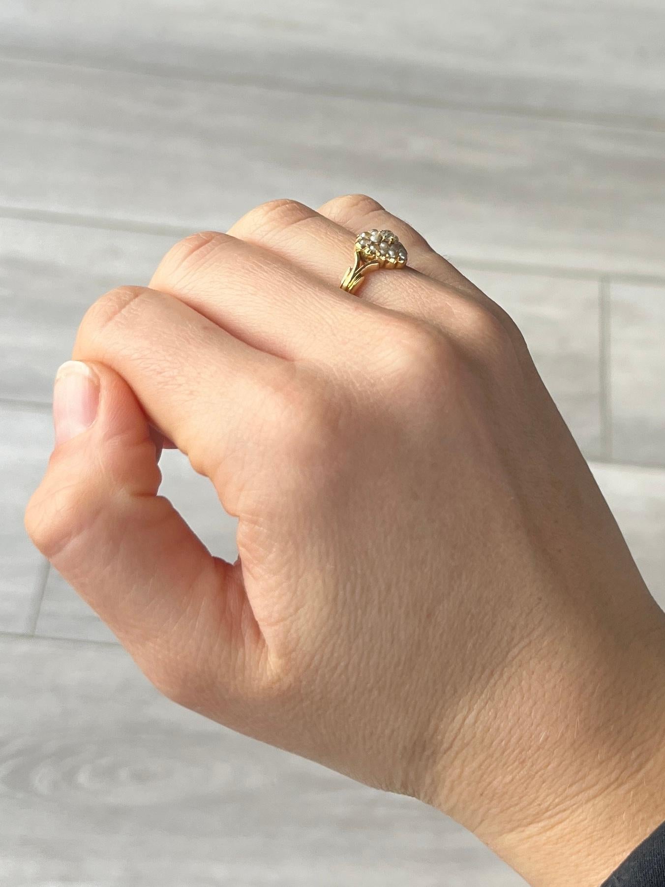 This sweet heart ring holds an old mine cut diamond at the centre measuring 10pts. Surrounding the diamond are lovely seed pearls. The split shoulders then join to create a detailed band which is all modelled in 18ct gold. Fully hallmarked