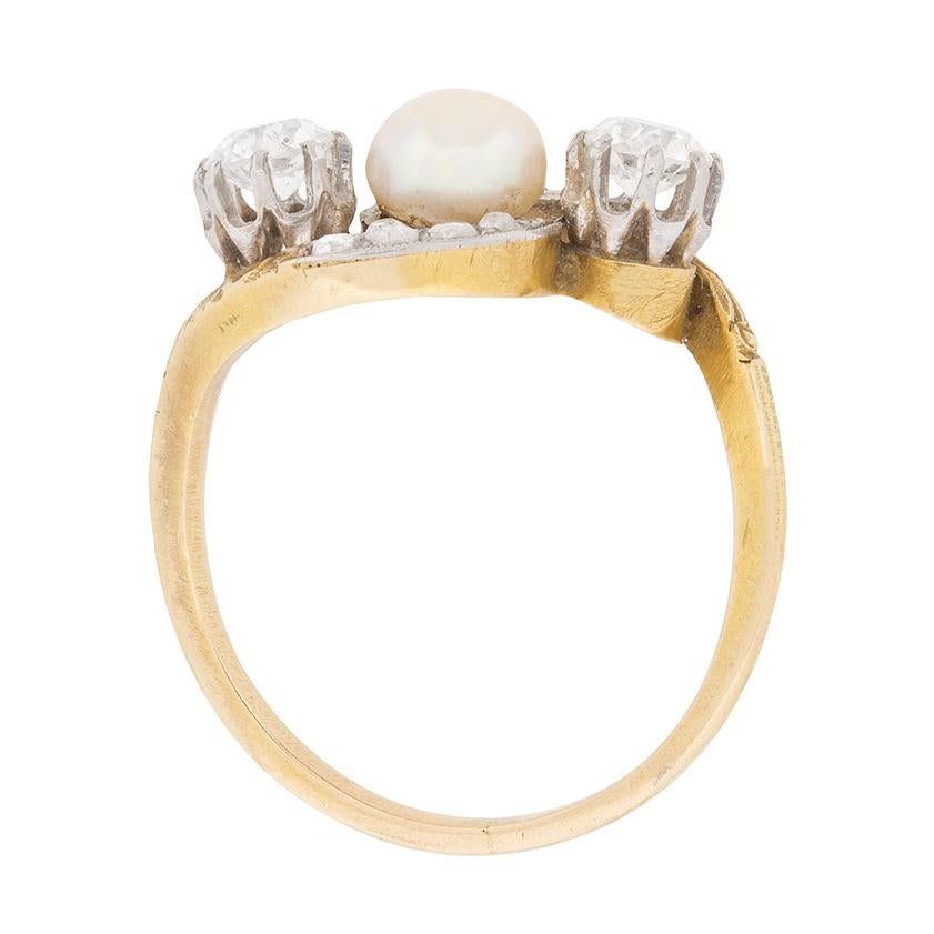 This tasteful diamond and pearl crossover ring was handmade in platinum and 18 carat yellow gold during the 1890s.

This elegant ring stars a twin old cut diamonds set diagonally in claw illusion settings to centre a creamy white pearl.

A quartet