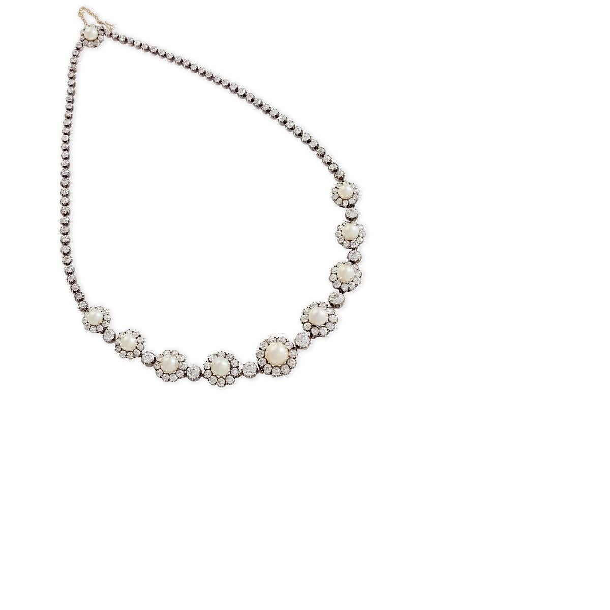 This classic necklace from the Victorian Era is composed of ten graduating natural saltwater button pearls and twenty carats of diamonds. Each natural saltwater pearl is framed by old European-cut diamonds joined by single-stone diamond links, and
