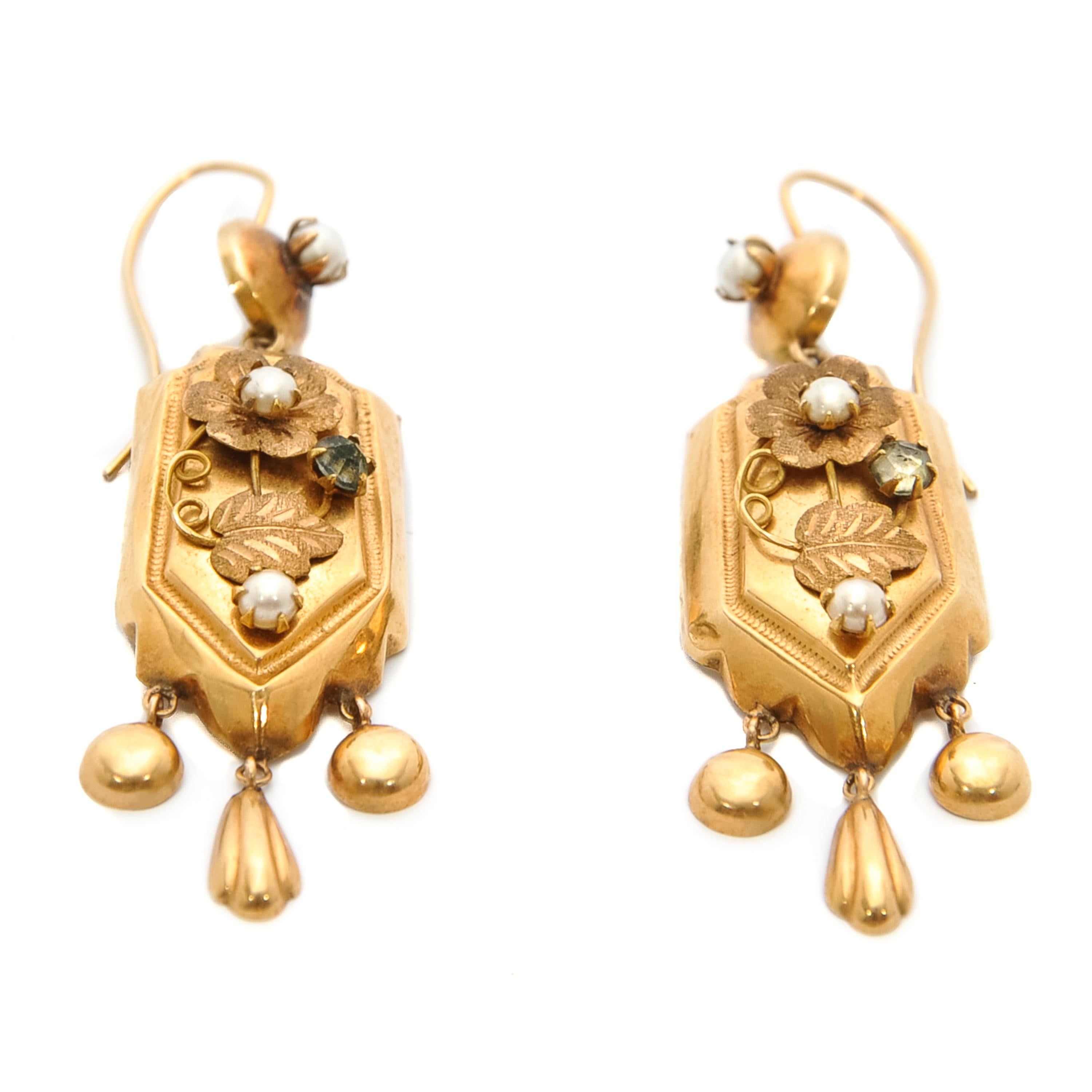 This amazing pair is searching for a new home! Maybe with you, or to give as a gift to a loved one?! 

These 18 karat yellow gold dangle earrings feature pearls and a diamond. The earrings are refined with a rich decoration of leaves, three clear