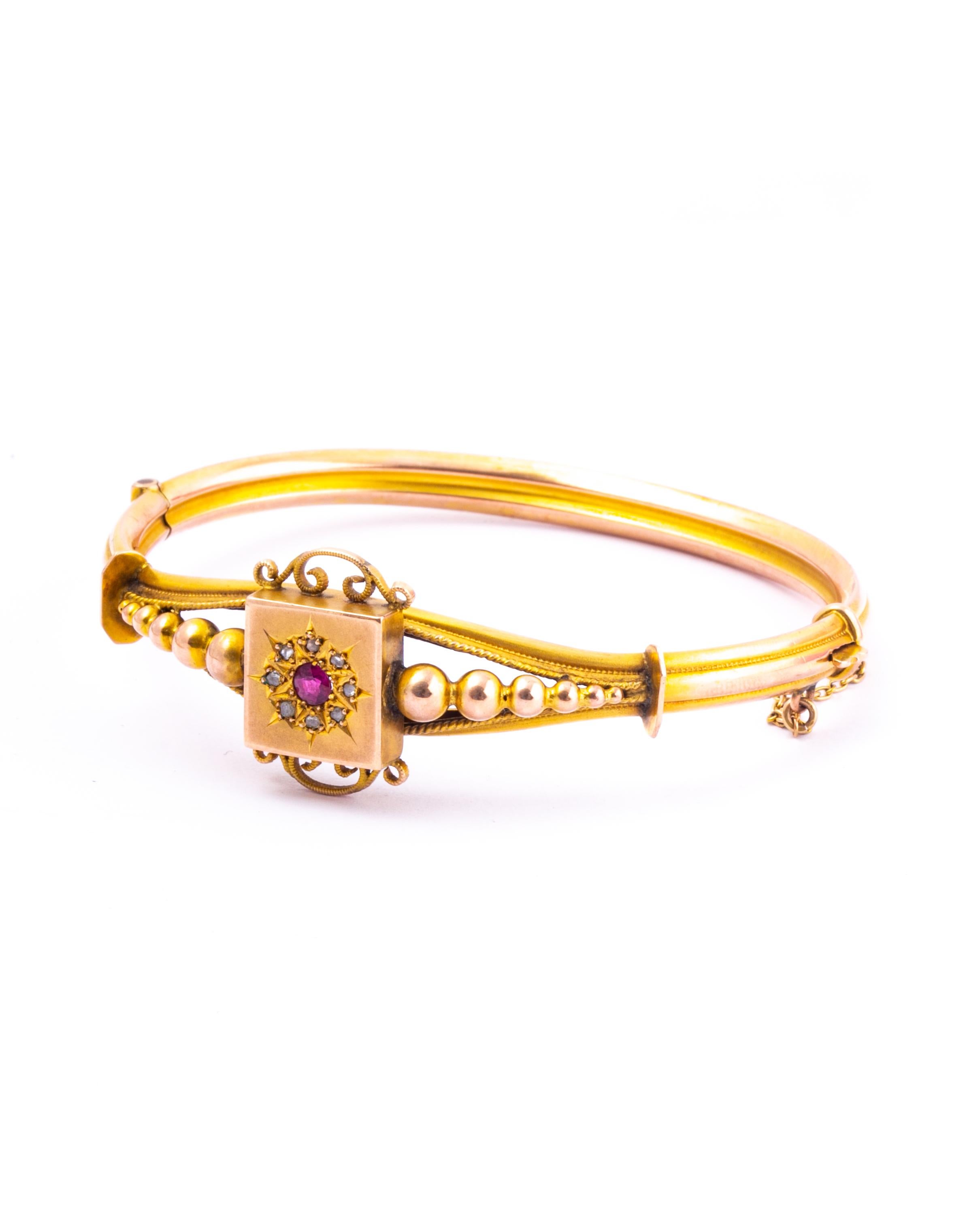 The 9 carat gold is glossy and the bangle has so much detail. The centre of the bangle holds a gorgeous and colourful ruby. Surrounding this is a halo of rose cut diamonds. Either side of the decorative panel is orb detailing. 

Inner Diameter: