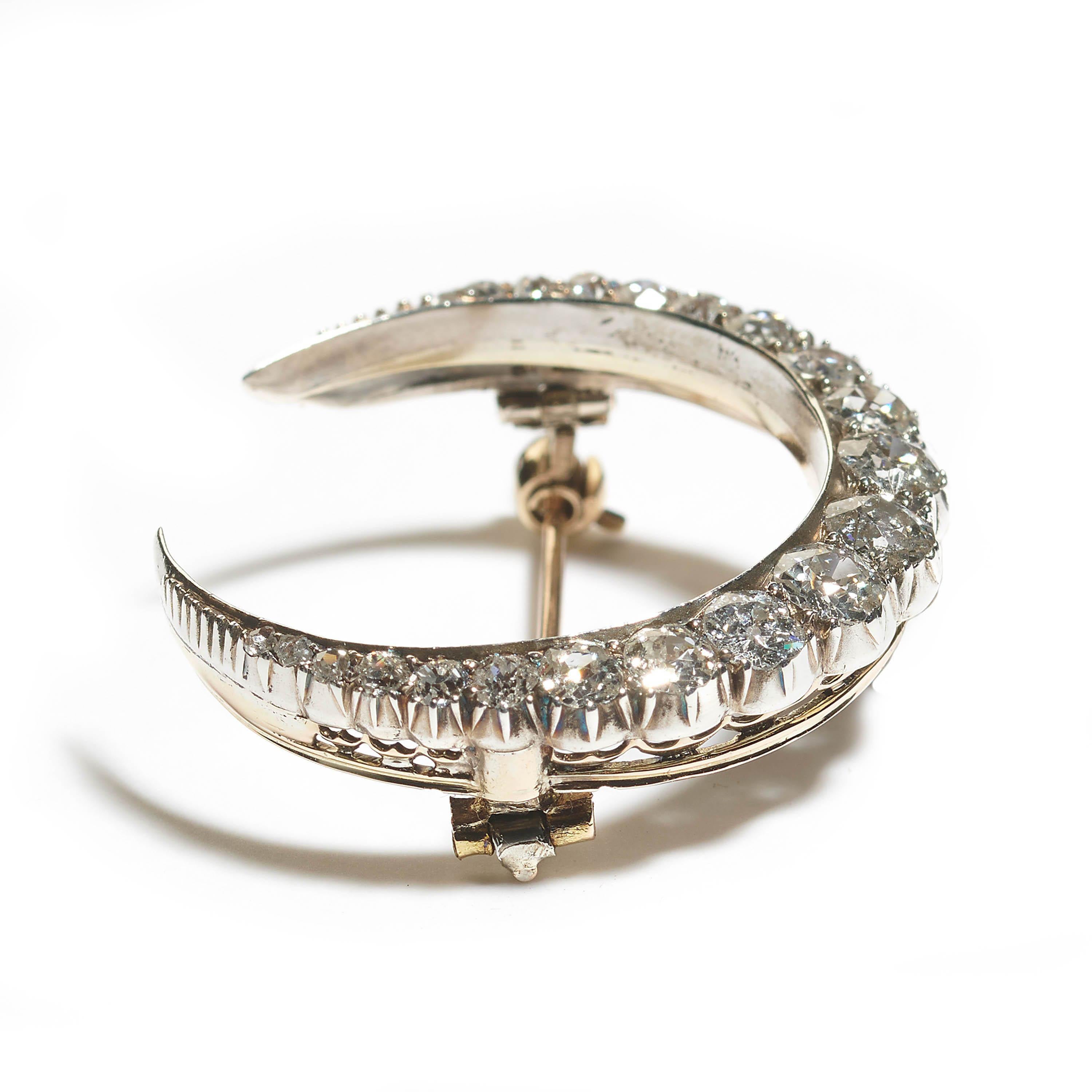 An antique crescent moon brooch, the body is set with a row of old-cut diamonds, graduating in size, tapering to rose-cuts, weighing an estimated total of 3.50 carats, claw set in silver-upon-gold, with a plain inner curve and cut down set outer