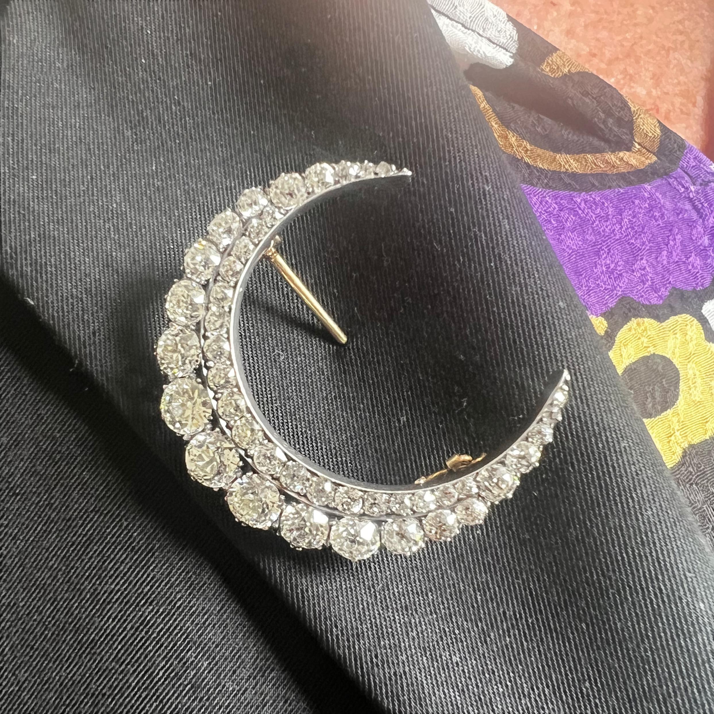 An antique crescent moon brooch, the body is set with two rows of old mine-cut diamonds, graduating in size, weighing an estimated total of 5.40 carats, claw set in silver-upon-gold, with a plain inner curve and cut down set outer curve, with gold