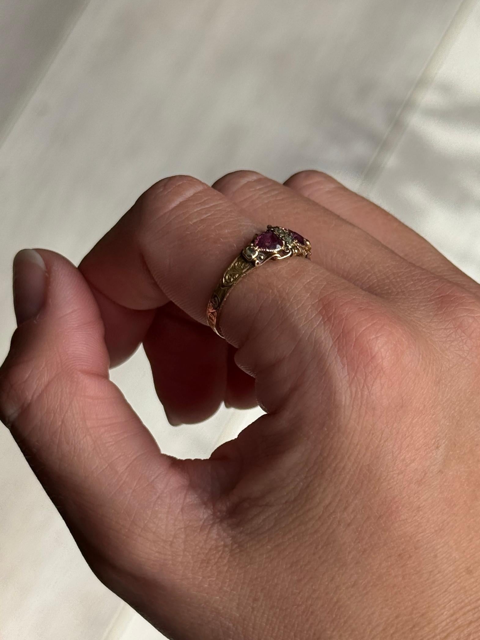 Este precioso anillo de oro de 15 ct contiene cuatro diamantes talla rosa y dos turmalinas rosas en forma de corazón. La banda tiene un intrincado grabado alrededor y en el interior del anillo figura la inscripción 