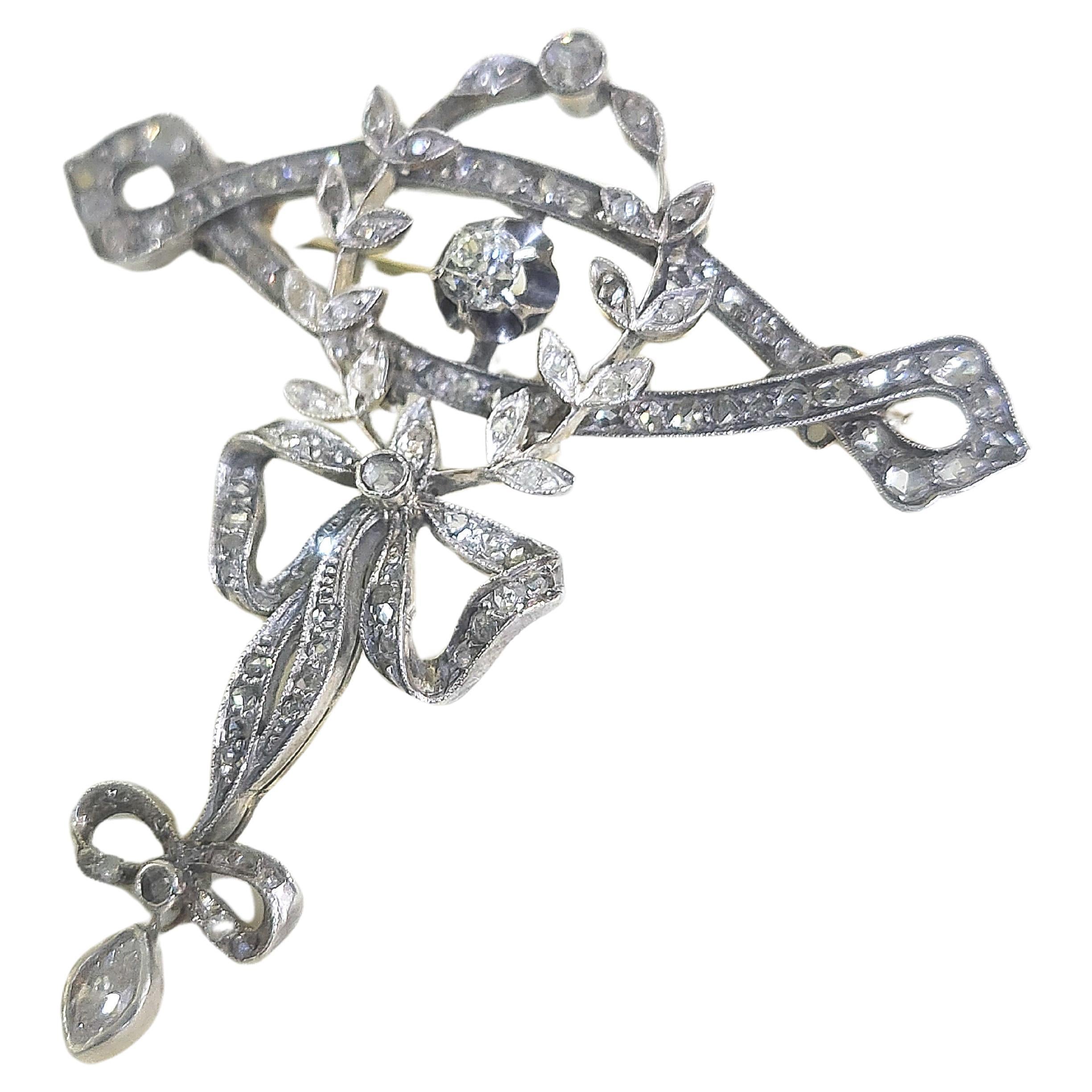 Victorian era 1850s brooch in open work designed with a ribbon with old mine cut diamonds and rose cut diamonds in gold toped with silver in fine workmanship total brooch lenght 4.5cm and estimate diamond weight 1 carat