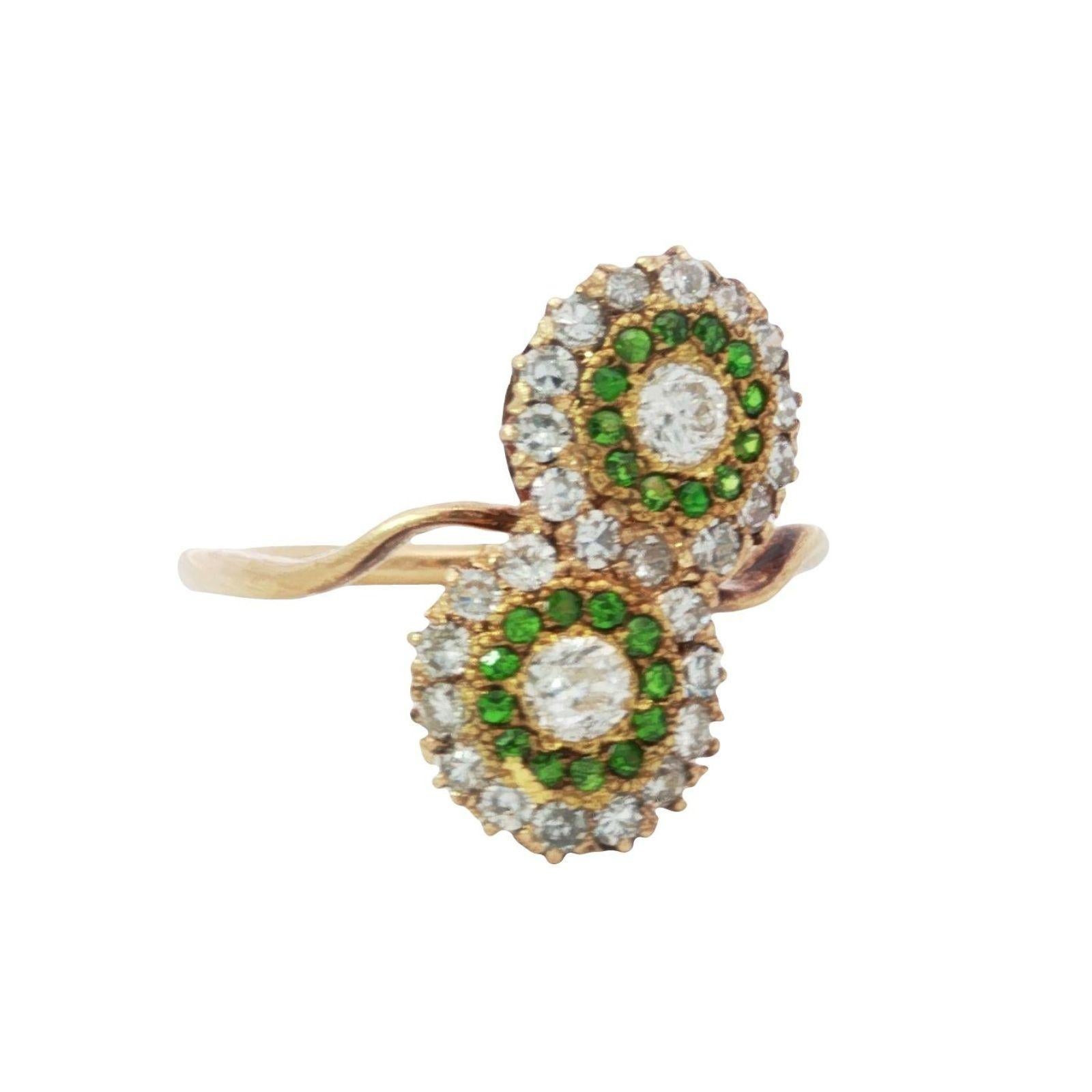 Anello vittoriano con diamante bypassato Granato demantoide in oro giallo 14K misura 7,5

Questo raffinato anello presenta due diamanti bianchi centrali, ciascuno incorniciato da una vivace aureola di demantoidi verdi. Il contrasto tra i diamanti