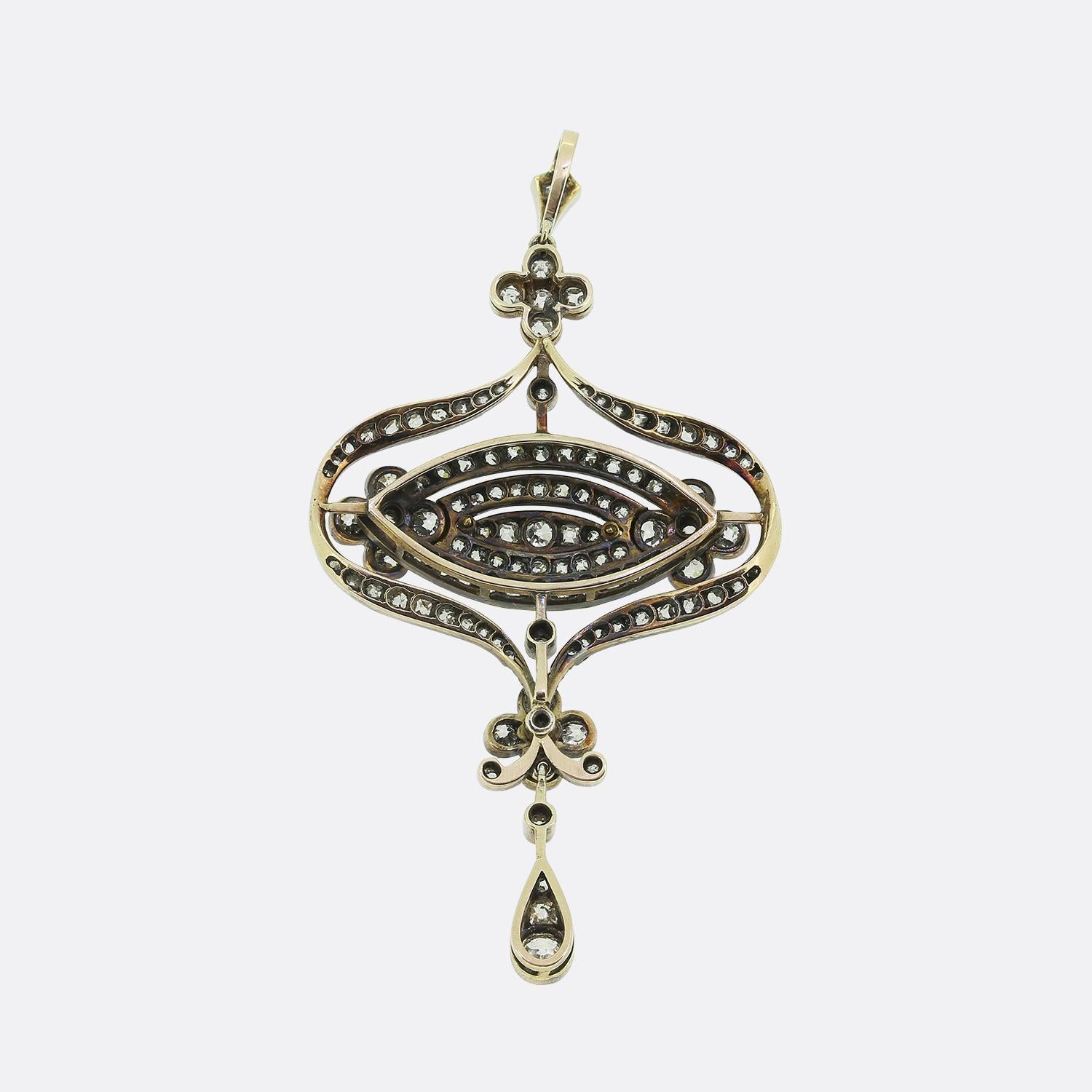 Ecco un delizioso ciondolo vittoriano a goccia. Realizzato in una miscela di oro e argento 18ct, mostra un intricato design sinuoso ornato da una vasta gamma di diamanti taglio old mine. La disposizione simmetrica dei diamanti del pendente offre un