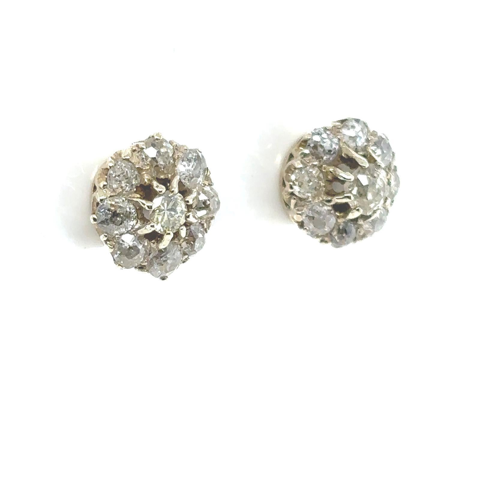 A pair of Victorian diamond cluster earrings in 18 karat yellow and white gold.

Each of these elegant stud earrings comprise of a single old cut diamond claw set within a border of eight further old cut diamonds within white gold claws to