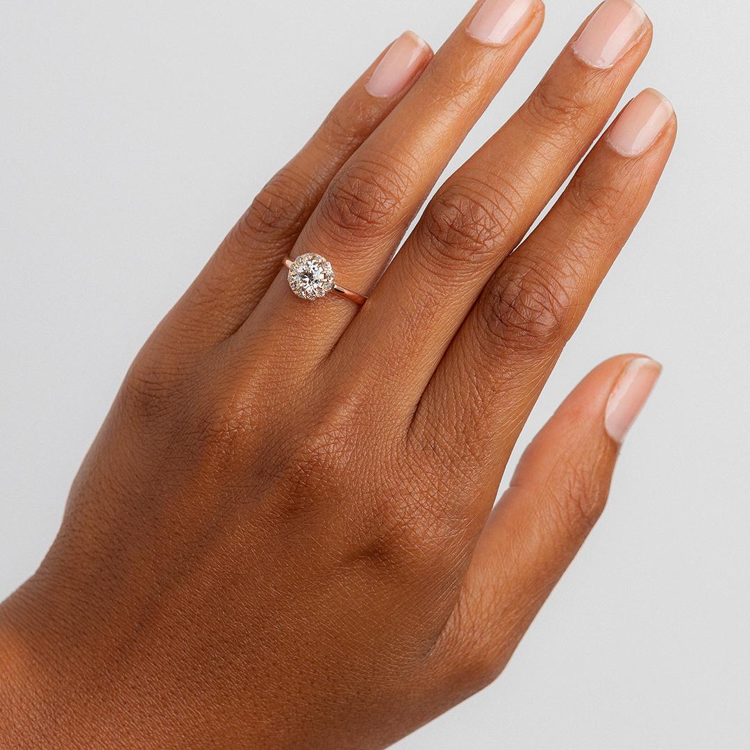 This is a delightful and delicate Victorian (circa 1895) 14k rose gold cluster ring. This antique halo centers a sparkling 0.79ct EGL certified Old European Cut diamond graded I color and VS2. An adorable halo of twelve Old Mine Cut diamonds