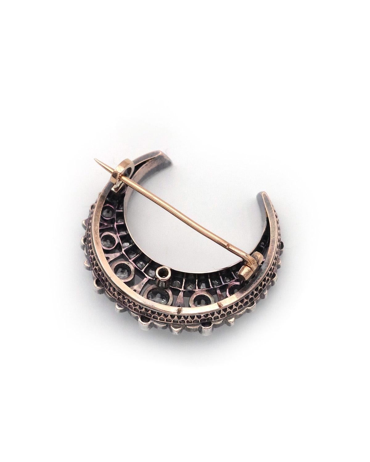 Luna creciente victoriana de diamantes en oro de 18 quilates y plata. Broche celeste que representa una luna creciente engastada con numerosos diamantes talla antigua. El peso total estimado del diamante es de 1,30 quilates. Antiguo broche de luna,