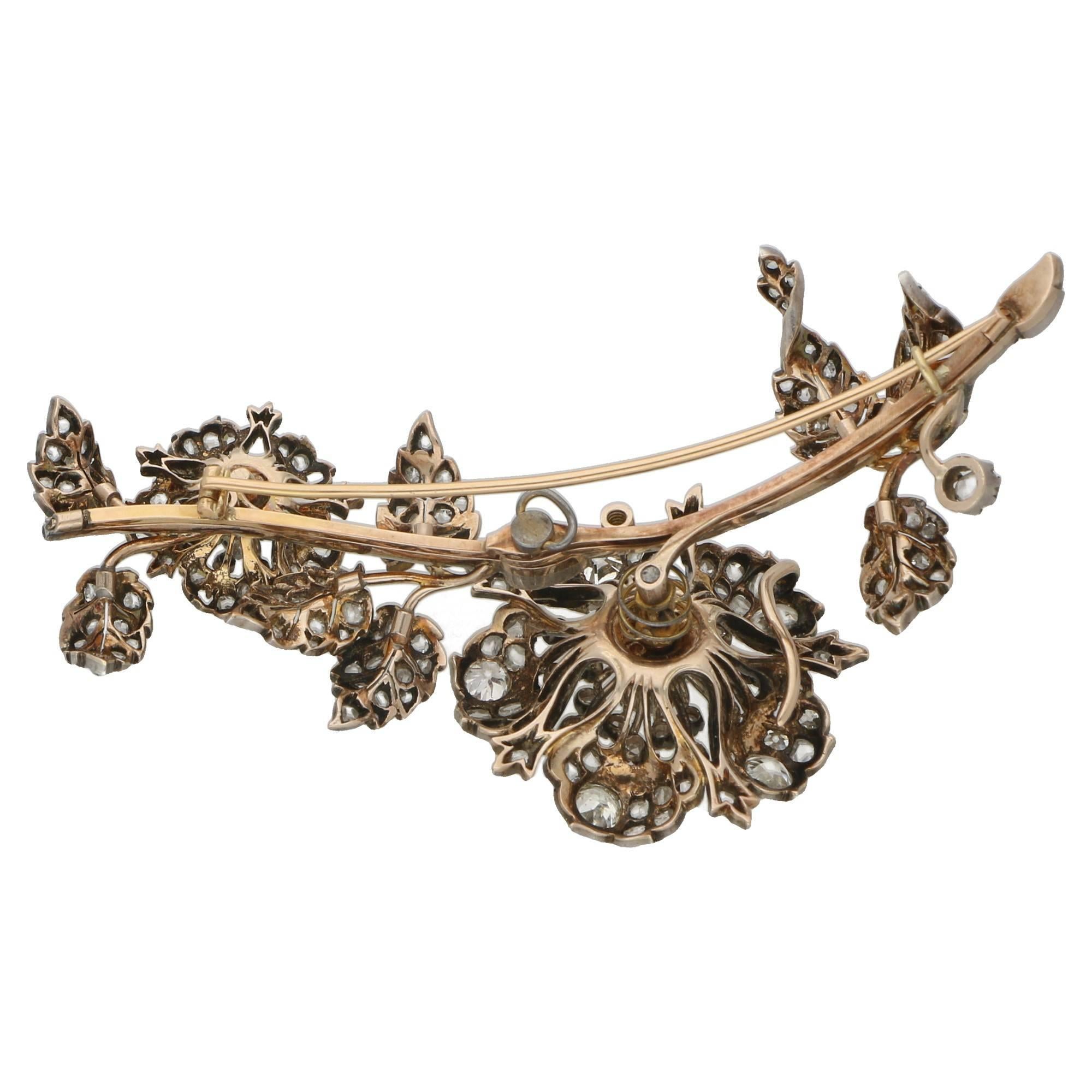 A notable Victorian diamond brooch set in silver on gold, designed as a floral and foliate spray centering on a detachable flower head set 