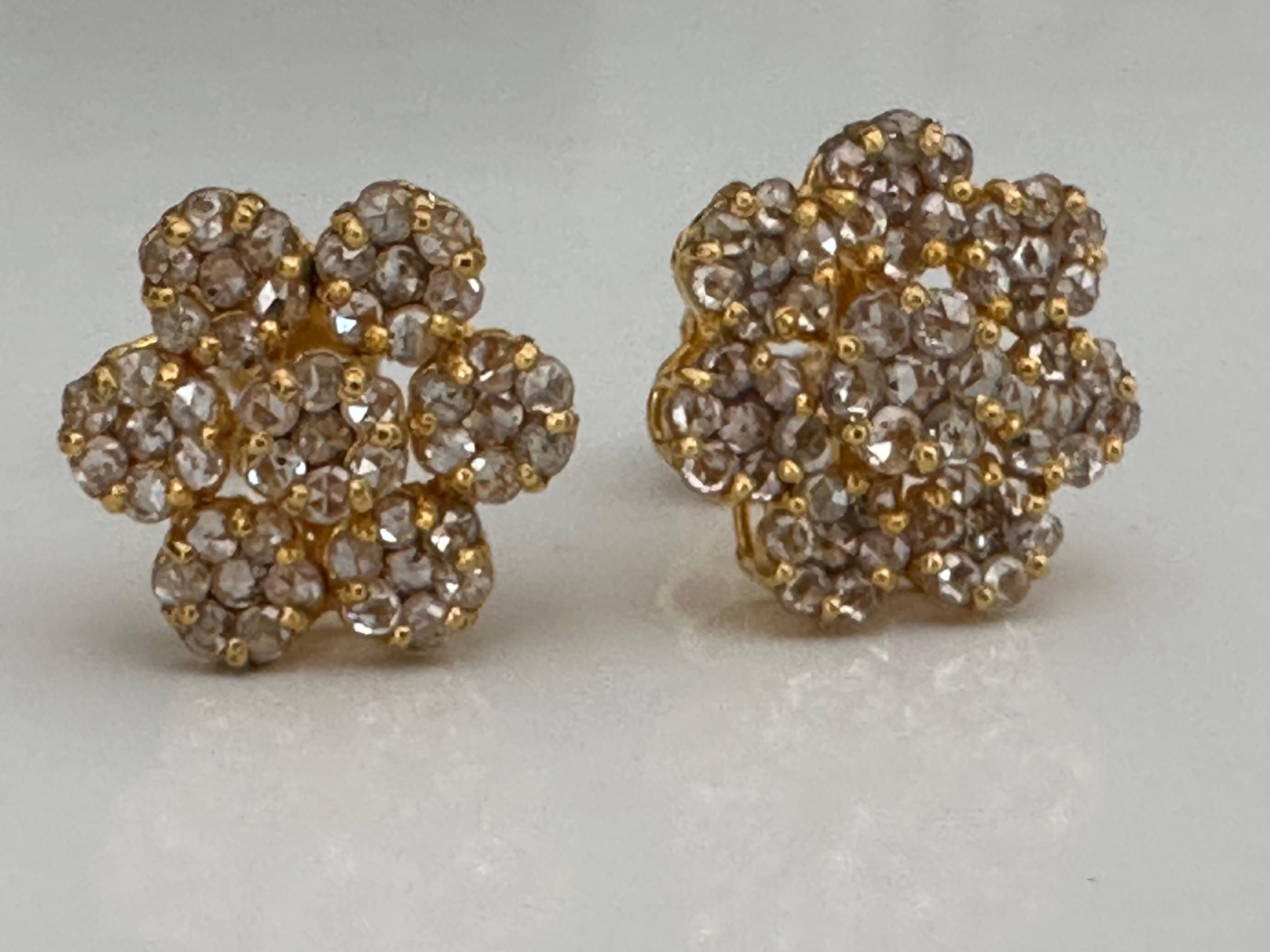 These antique flower-shaped stud earrings hand carved from 22K yellow gold feature ninety-eight rose cut diamonds totaling approximately 1.47 carats and secured with original screw back posts. Circa 1900. 
