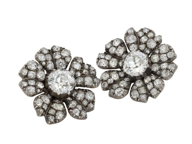 Victorian diamond flower earrings. A matching pair, set to centre with one cushion shape old mine diamond in an open back cut-down setting, two in total with a combined approximate weight of 4.20 carats, further set with fifty one cushion shape old
