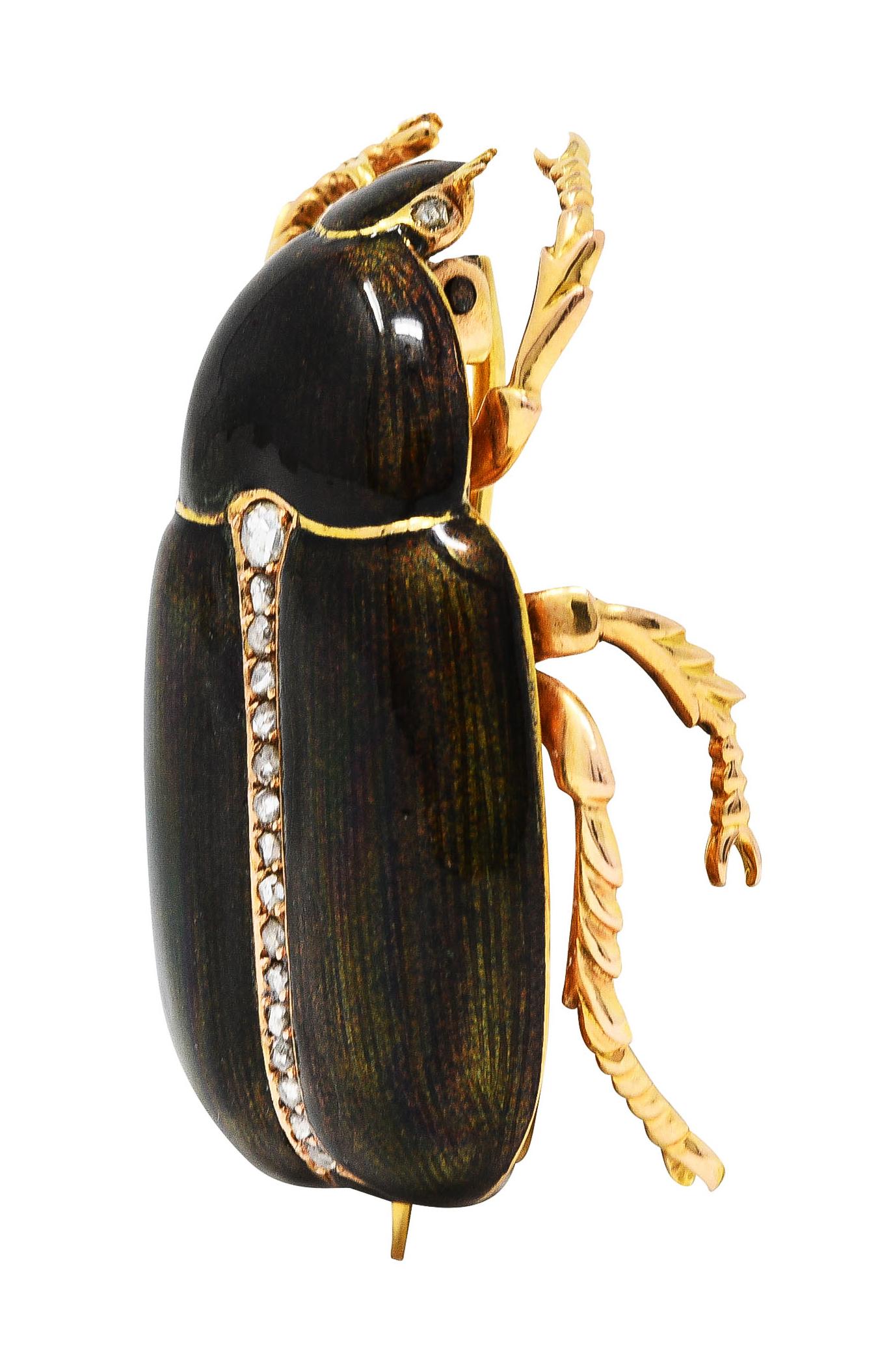 Brooch is designed as a highly rendered gold scarab beetle with grooved limbs. Featuring a guillochè enamel body - translucent glossy greenish to greenish brown. With an engraved linear pattern throughout - exhibiting minimal loss. Accented by rose