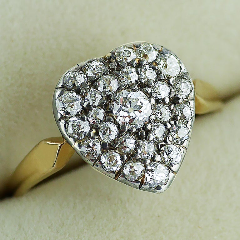 18ct gold and silver set Victorian Diamond Heart shaped ring, circa 1870. 

Heart shaped design in 18ct yellow gold and silver set with 27 old cut, well matched diamonds. The ring shank in 18ct yellow gold with a fine pierced gallery and fret work
