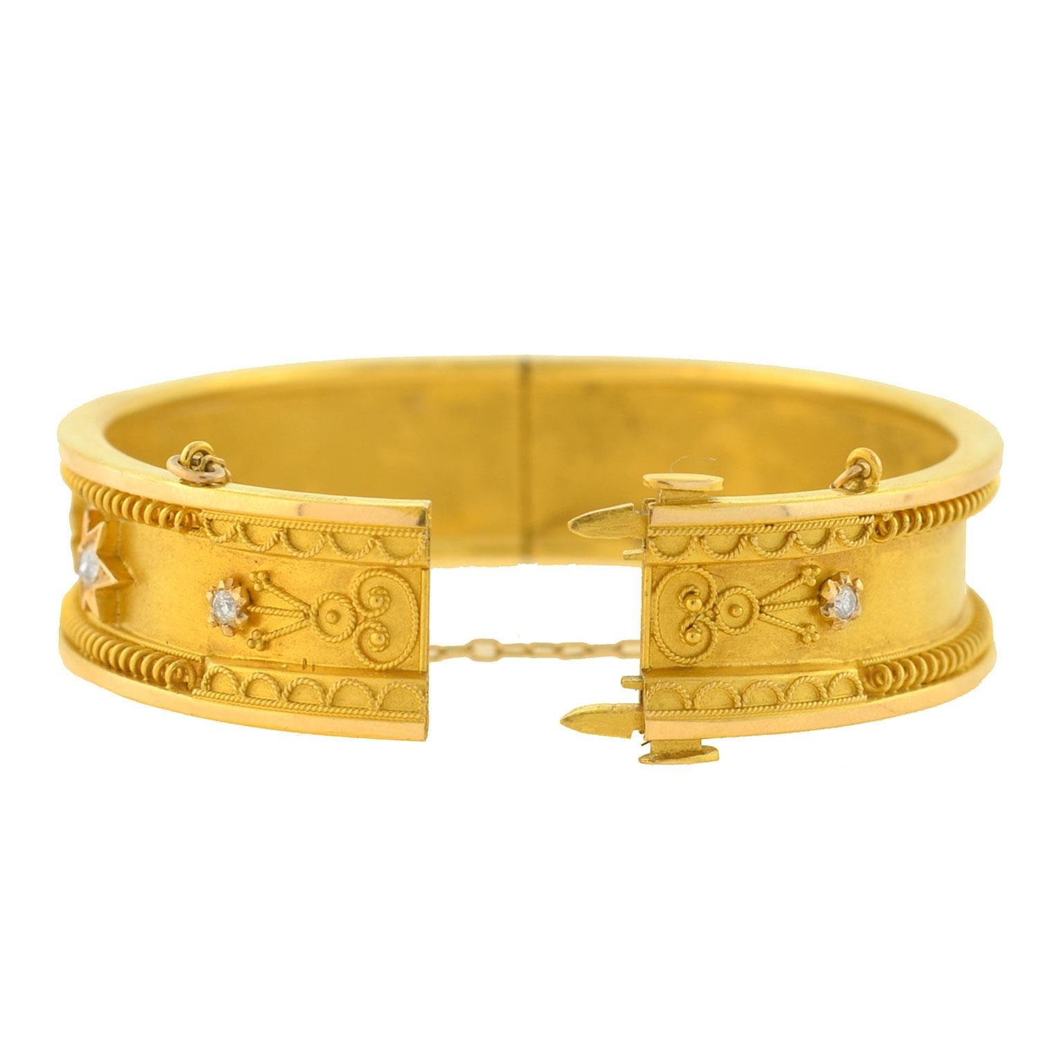 A gorgeous gold bangle bracelet from the Victorian (ca1880) era! Crafted in vibrant 18kt yellow gold, this hinged bangle has a fine coiled wirework design that borders the top and bottom edges, carrying around both sides of the piece. Soft Etruscan