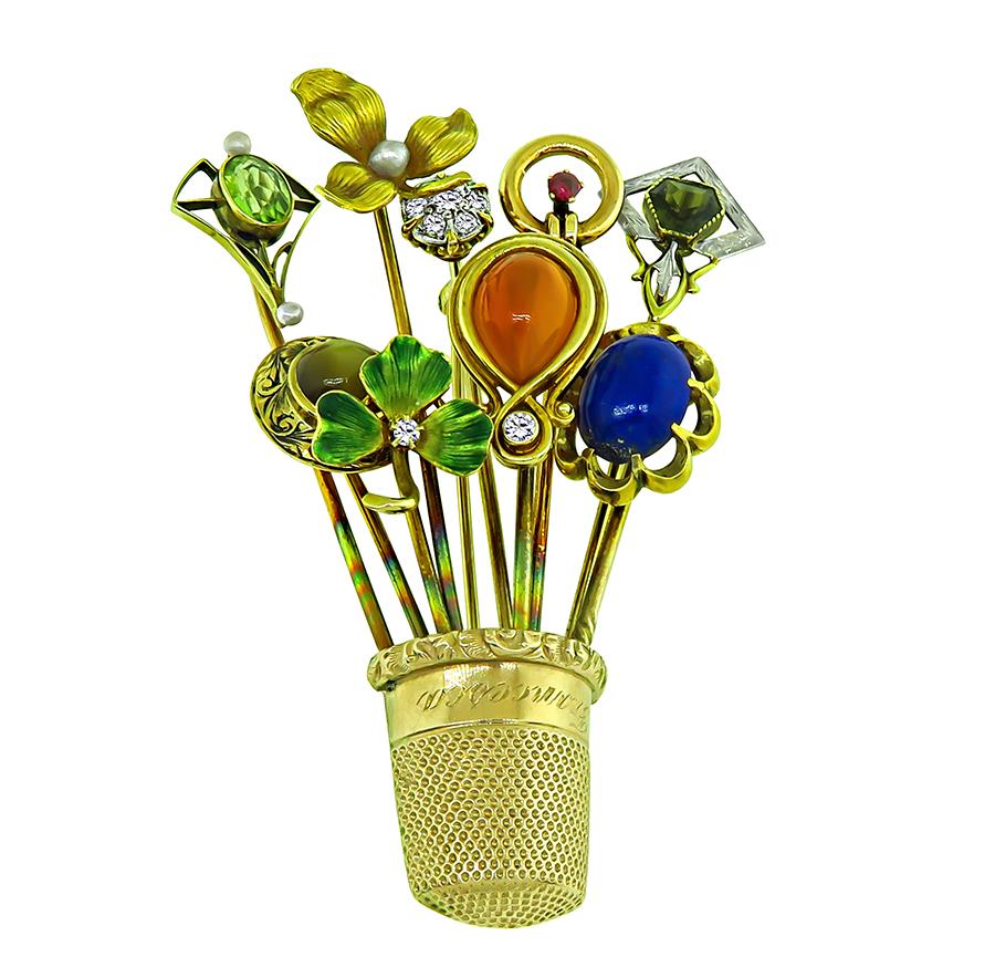 This is an elegant 14k yellow gold thimble basket pin from the Victorian era. The pin is set with old mine cut diamonds, cabochon agate, lapis and tiger's eye, oval cut peridot, round cut pink tourmaline, trapezoid green tourmaline and lovely round