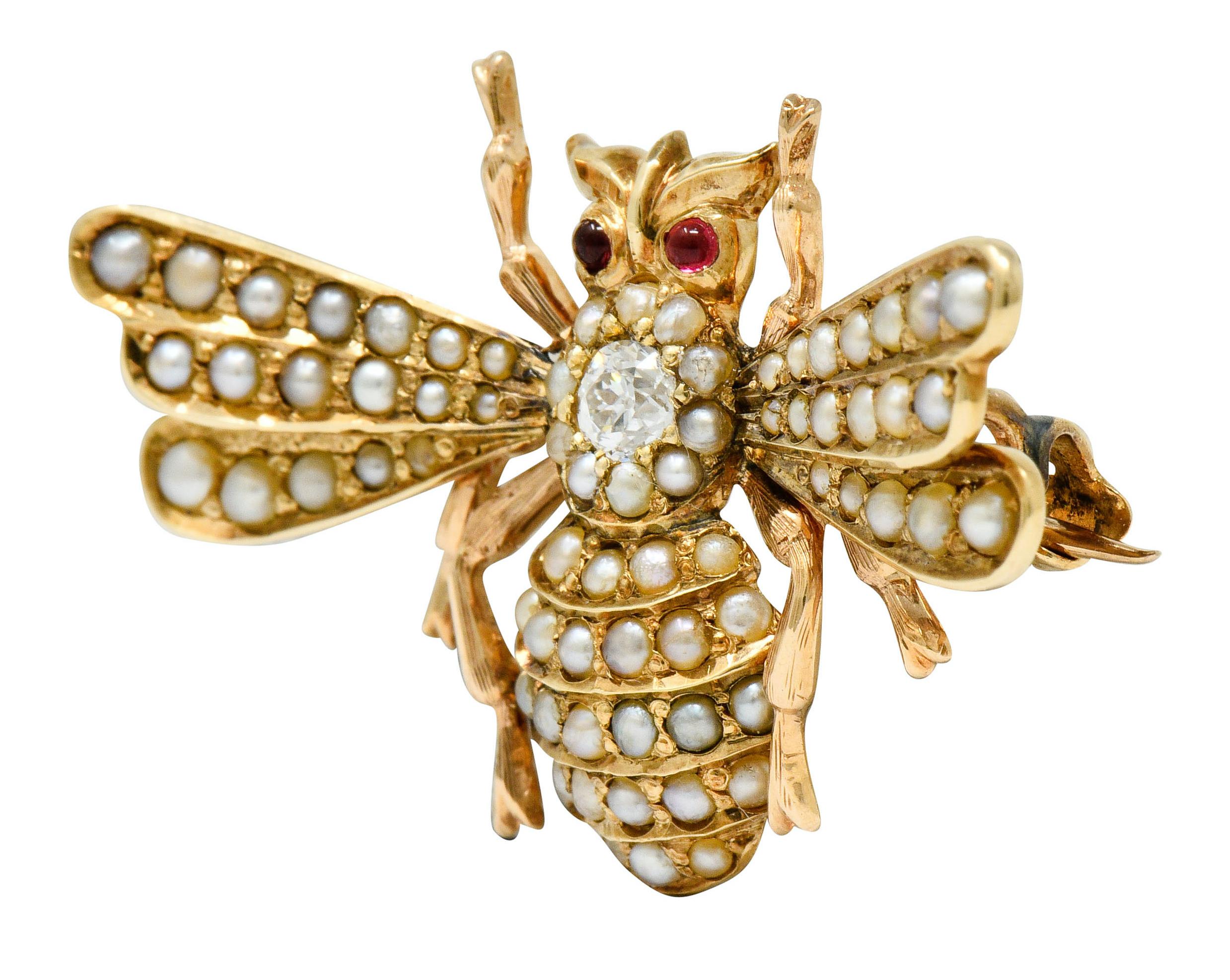Brooch is designed as winged bee-like insect with adorable polished gold appendages and accented by ruby cabochon eyes

Centering a bead set old European cut diamond weighing approximately 0.18 carat, G color with SI clarity

Set throughout by rows