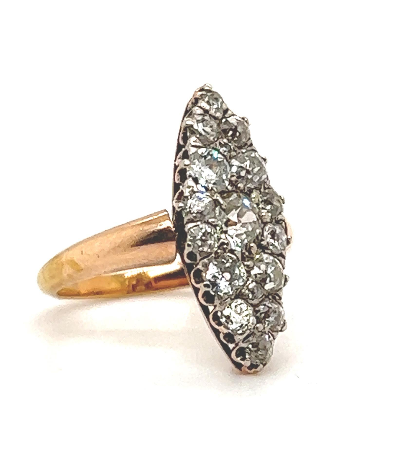 Elegant and classic design seen on this Victorian diamond navette ring. The ring is set with old mine cut diamonds in a cluster formation. All diamonds in the design graduate in size looking like one large cut antique marquise cut diamond. This