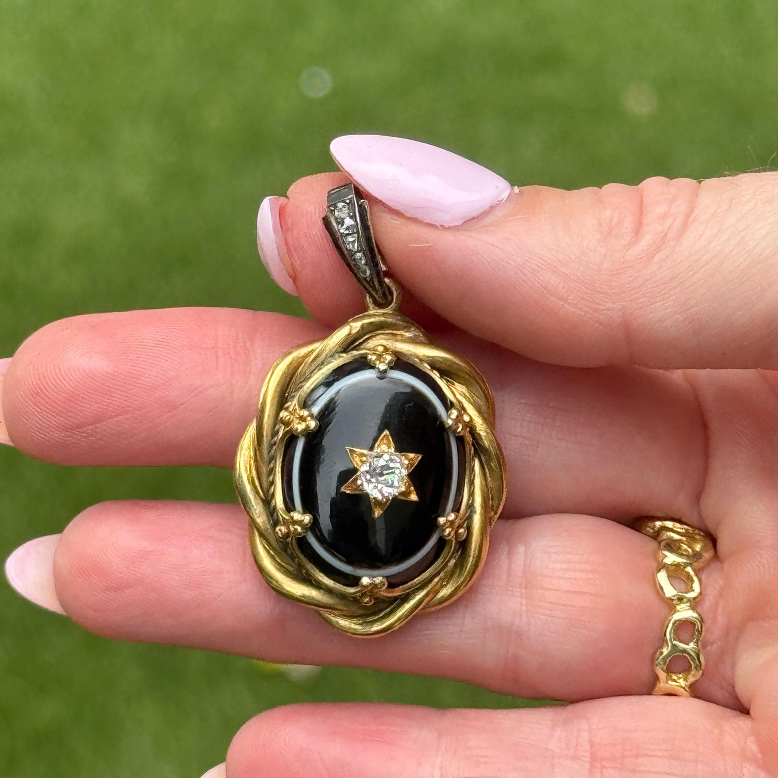 Questo squisito medaglione vittoriano è realizzato in oro giallo 18 carati e presenta un suggestivo pannello di onice con incastonato un diamante vecchio taglio europeo di circa 0,33 carati, di colore H e purezza SI. Cinque ulteriori diamanti con