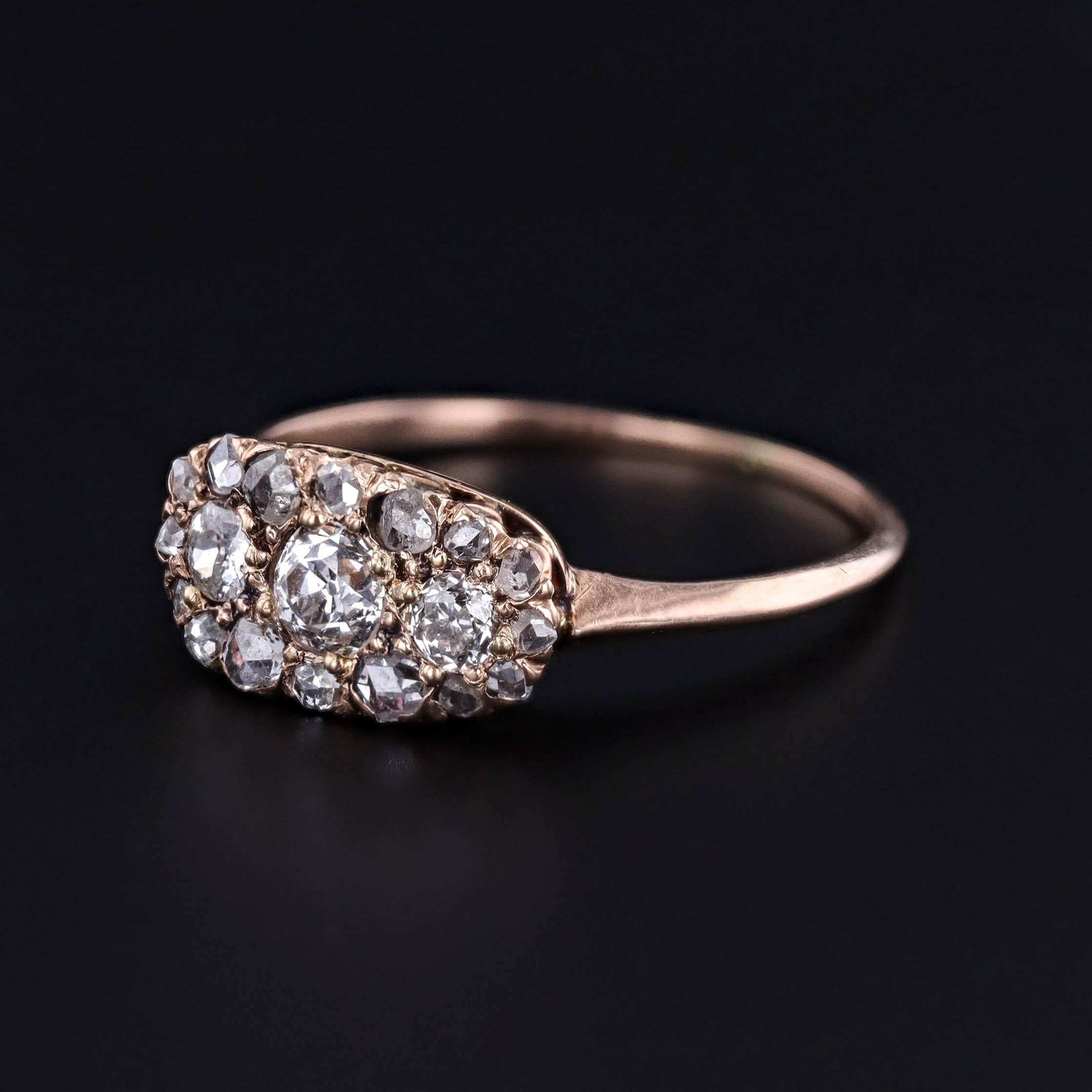 Un antico anello di epoca vittoriana, risalente al 1890, con tre diamanti taglio vecchio europeo e 16 diamanti taglio rosa incastonati in oro giallo 10k.  

La faccia dell'anello misura 0,3 pollici per 0,5 pollici di larghezza ed è in ottime