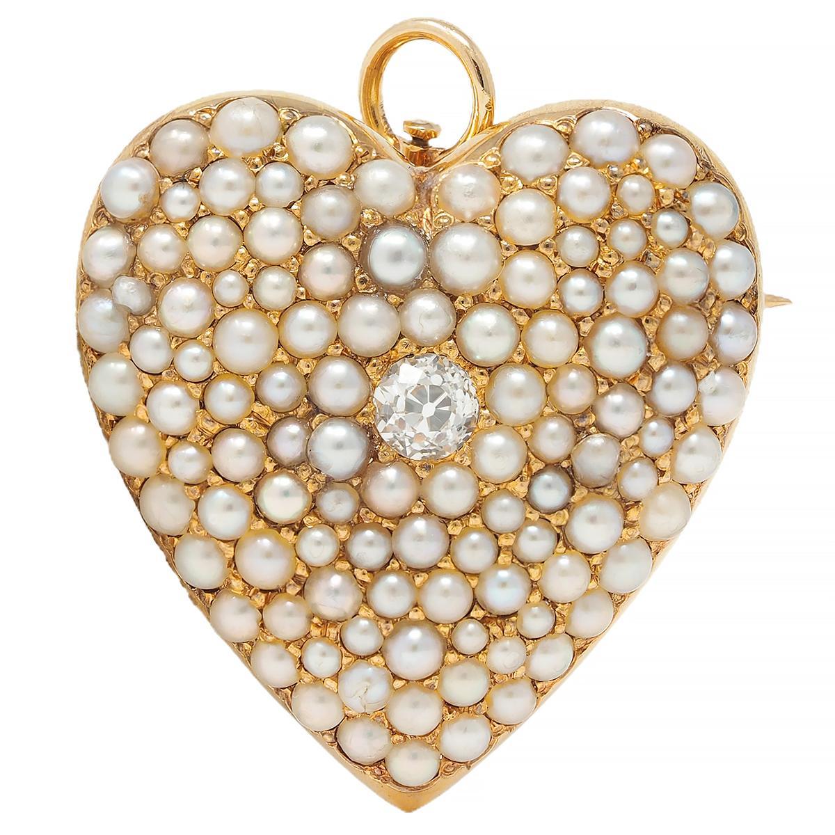 Designed as a domed heart-shaped form centering an old European cut diamond
Bead set and within approximately 0.10 carat - eye clean and bright
With a clustered surround of bead set seed pearls 
Ranging in size from 1.5 to 2.5 mm round 
White, gray,