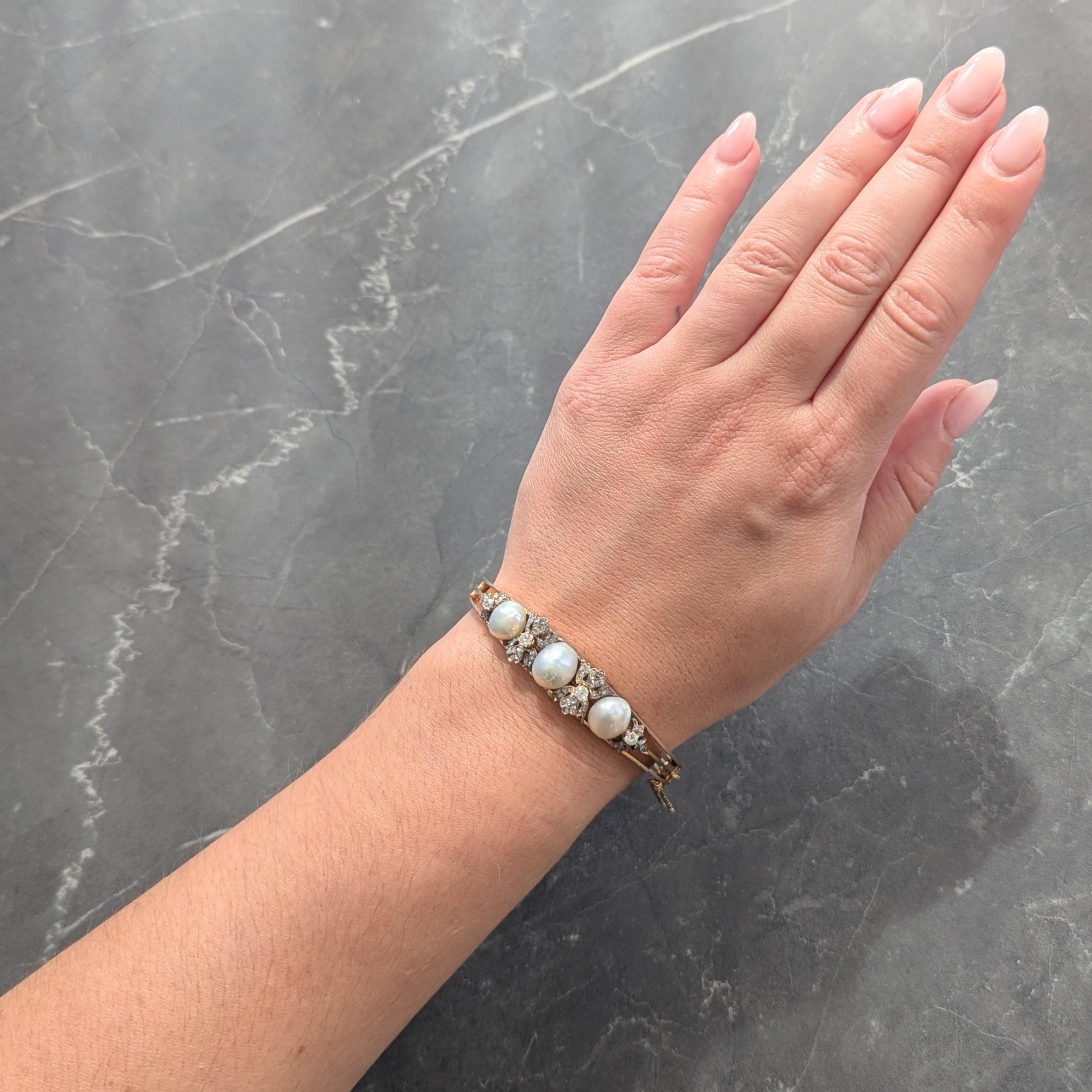 Bracelet de forme ovale centré sur trois perles et des appliques de feuillage.
Whiting de 9,5 à 10,0 mm presque rond - blanc avec une forte iridescence
Les feuilles sont surmontées d'argent et chaque centre est constitué de diamants taillés à