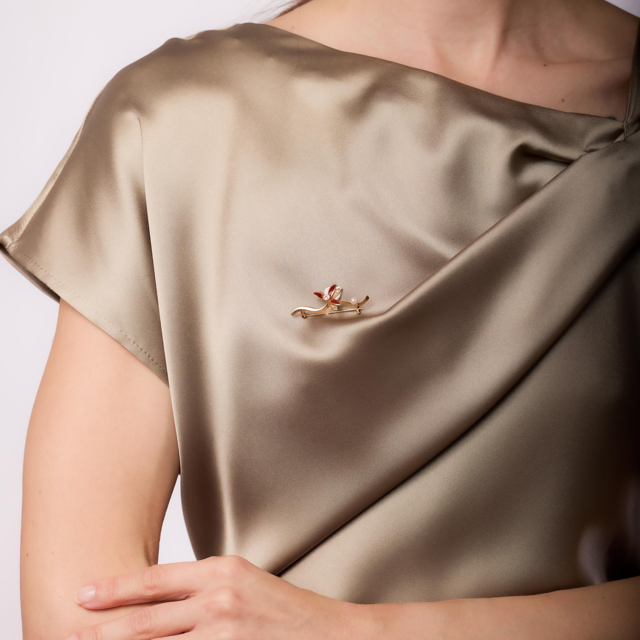 This Victorian 14k rose gold flower brooch features 11 old European and single cut diamonds totaling approximately 0.25 carats, G-H color, SI clarity, with a 3.68mm pearl accent. Intricately adorned with red enamel, this antique piece exudes