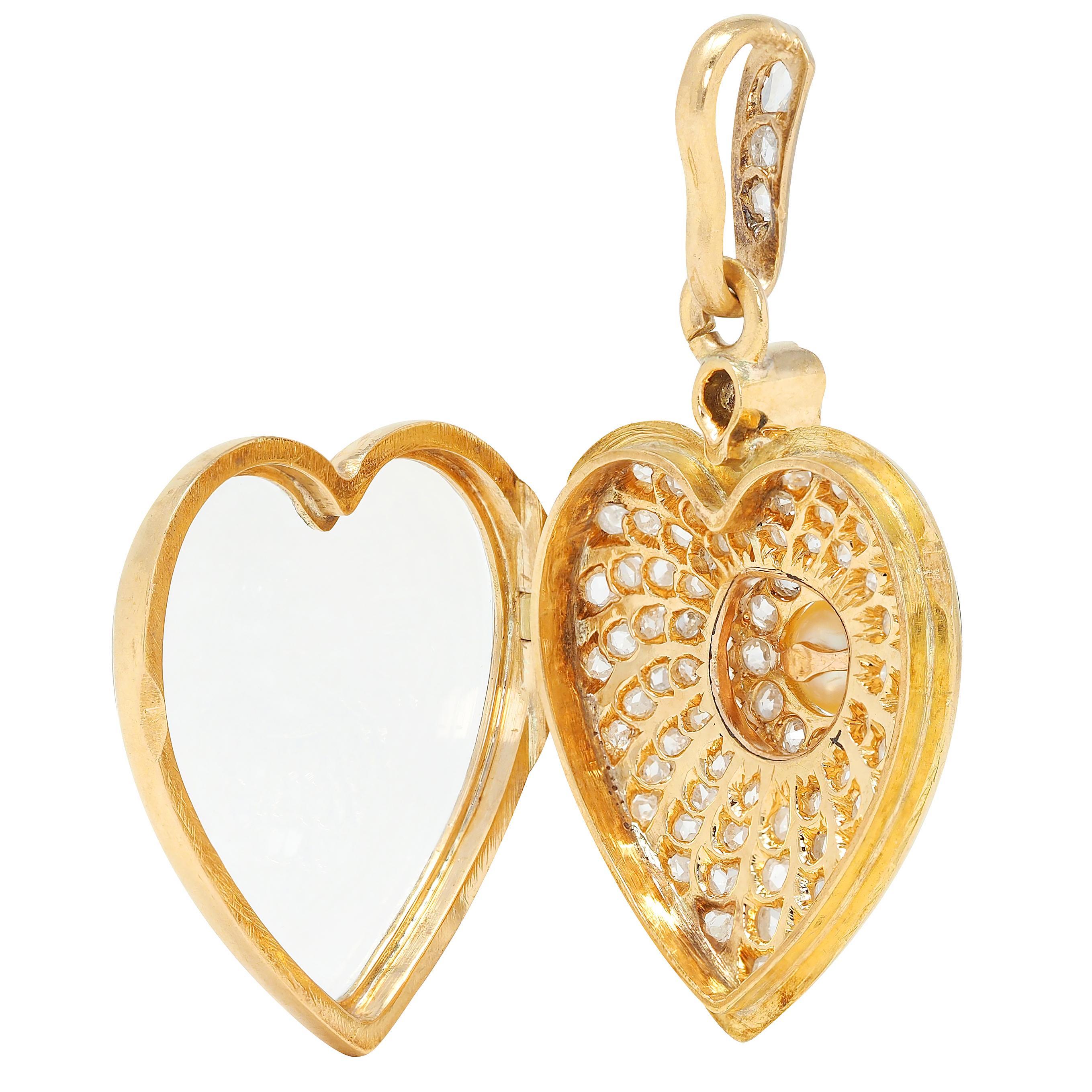 Pendentif en forme de cœur suspendu à une balle effilée.
Centrage d'une perle bouton ronde de 6,0 mm - crème avec forte iridescence
Entourée d'un halo de diamants anciens de taille unique sertis à l'emporte-pièce
D'un poids total d'environ 0,48