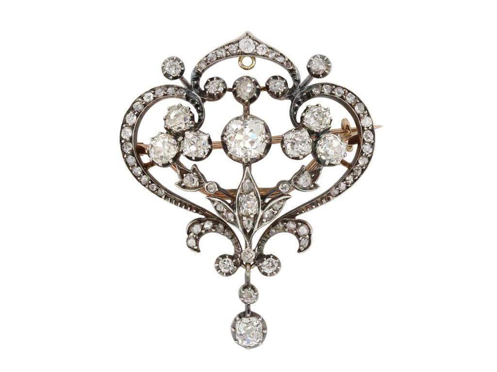 Victorian diamond pendant/brooch. Centrally set with a cushion shape old mine diamond in an open back cut-down setting with an approximate weight of 1.35 carats, adorned with twenty eight cushion shape old mine diamond in open back cut-down settings