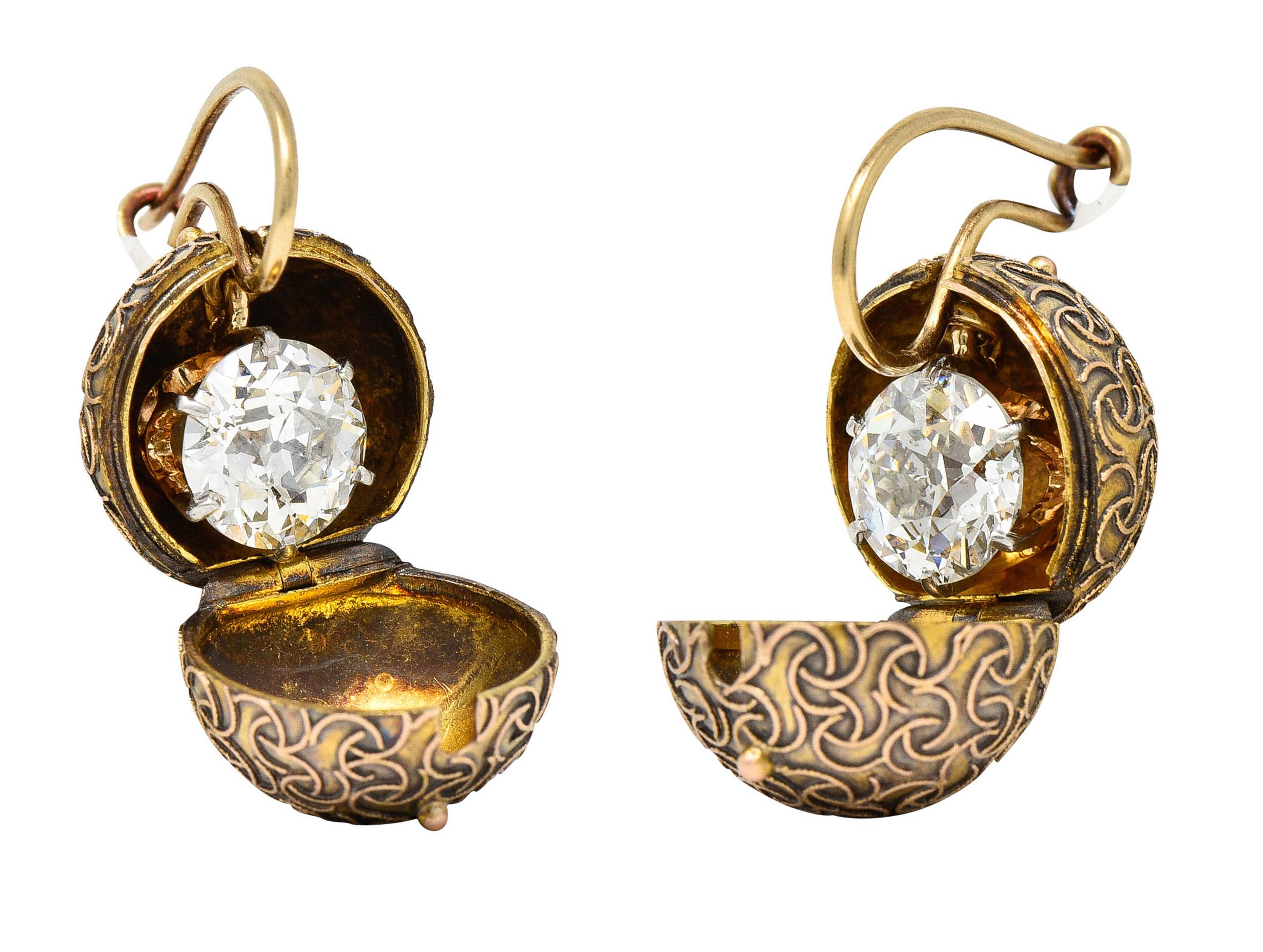 Drop earrings are encased in domed ball carriage covers

Decorated with raised scrollwork throughout and open on a hinge to reveal diamonds

Old European cut diamonds weigh in total approximately 3.18 carats - J/K in color with SI1 clarity

Talon