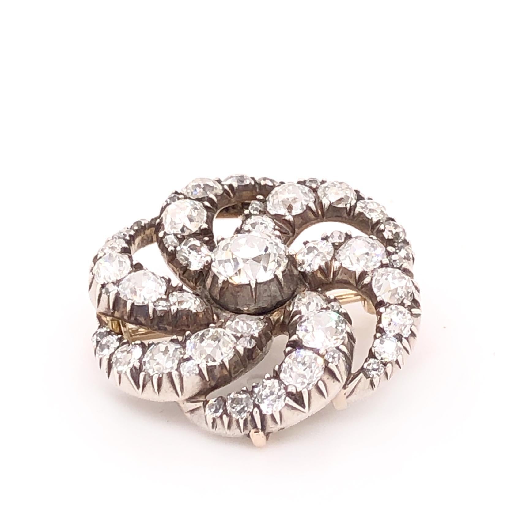 A beautiful Victorian diamond brooch, 1880s, in the form of a swirl. The design hints at a wind or water swirl and has very eye pleasing symmetry. The old European cut diamonds are of very good quality and weigh approximately 4 carats. The brooch