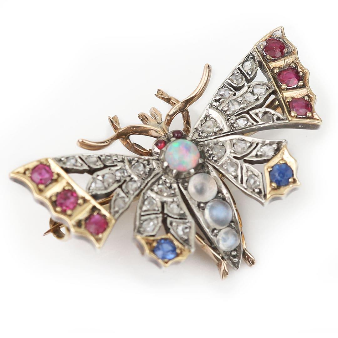 A beautifully ornate Victorian butterfly brooch decorated in variety of five precious gems and set in hand crafted fold on silver body and dates from circa 1885. This wonderfully colourful Victorian butterfly brooch is adorned with beautiful gem-set
