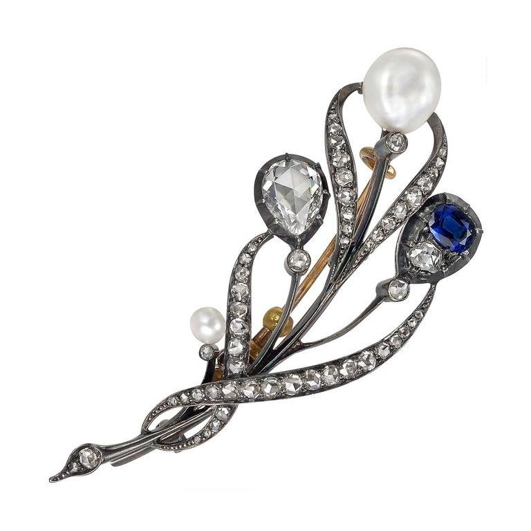 Victorian pin, showcasing a large rose-cut pear-shaped diamond, oval-shaped sapphire and pearl, with smaller old mine diamond accents, mounted in silver-topped gold, circa 1890. Rose-cut pear-shaped diamond weighing approximately 1.00 carats and