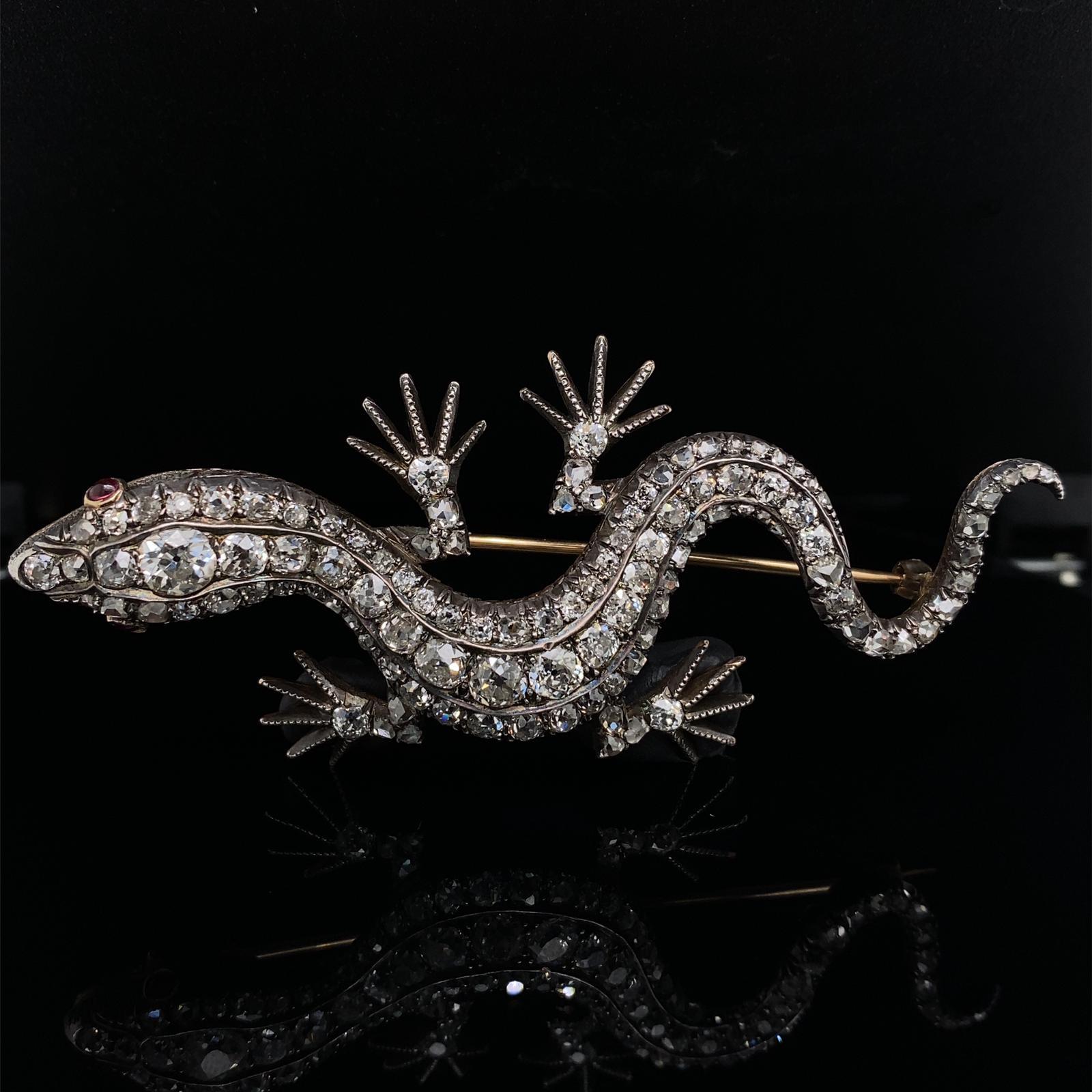 A Victorian diamond set lizard brooch in silver and yellow gold

This late 19th Century brooch, takes the elegant form of a lizard in motion, set throughout with old European and rose-cut diamonds with the largest to the head and central section of