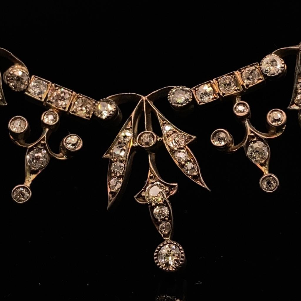 A Victorian diamond necklace in silver and yellow gold.

A striking necklace set in the era’s recognizable silver-on-gold setting.

This mid nineteenth century necklace is formed of thirteen diamond drop motifs which sit above the collarbone for an