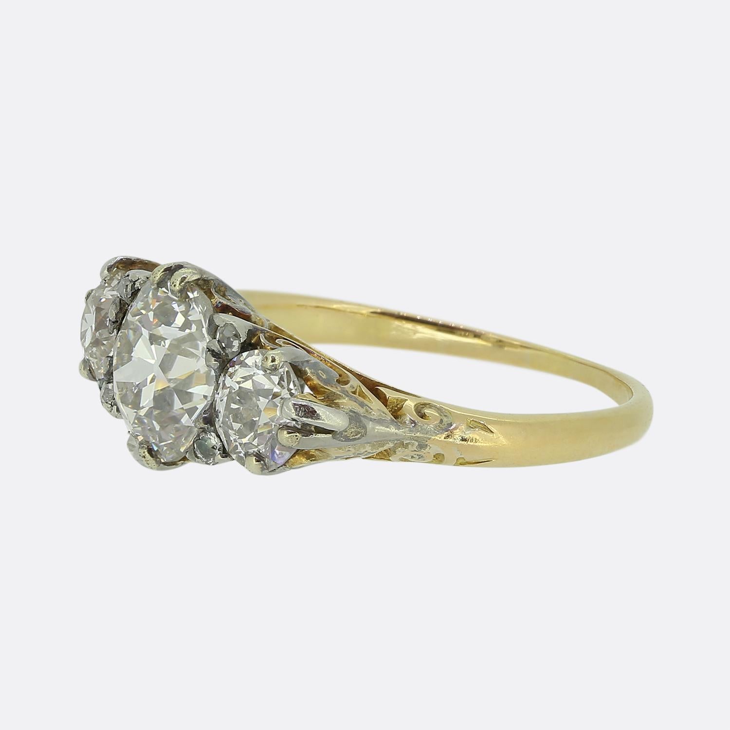 Aquí tenemos un anillo de tres piedras de estilo clásico tomado de la época victoriana. Esta pieza antigua está elaborada en rico oro amarillo de 18 ct y presenta tres cautivadores diamantes de talla europea antigua. Este trío ocupa un lugar