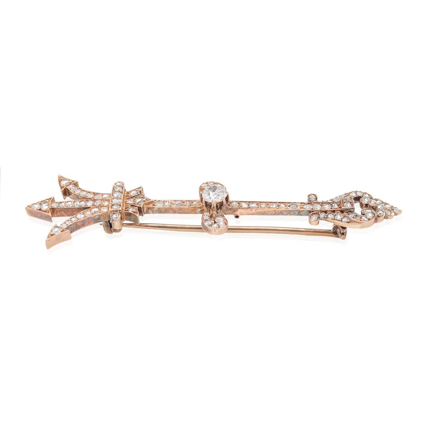 A unique pin from the Victorian (ca1880s) era! Crafted in 18kt rosy gold, this eye-catching piece is in the form of a diamond-encrusted trident. Approximately 0.50ctw of glittering Rose Cut diamonds adorn the surface of the elaborate hilt and the