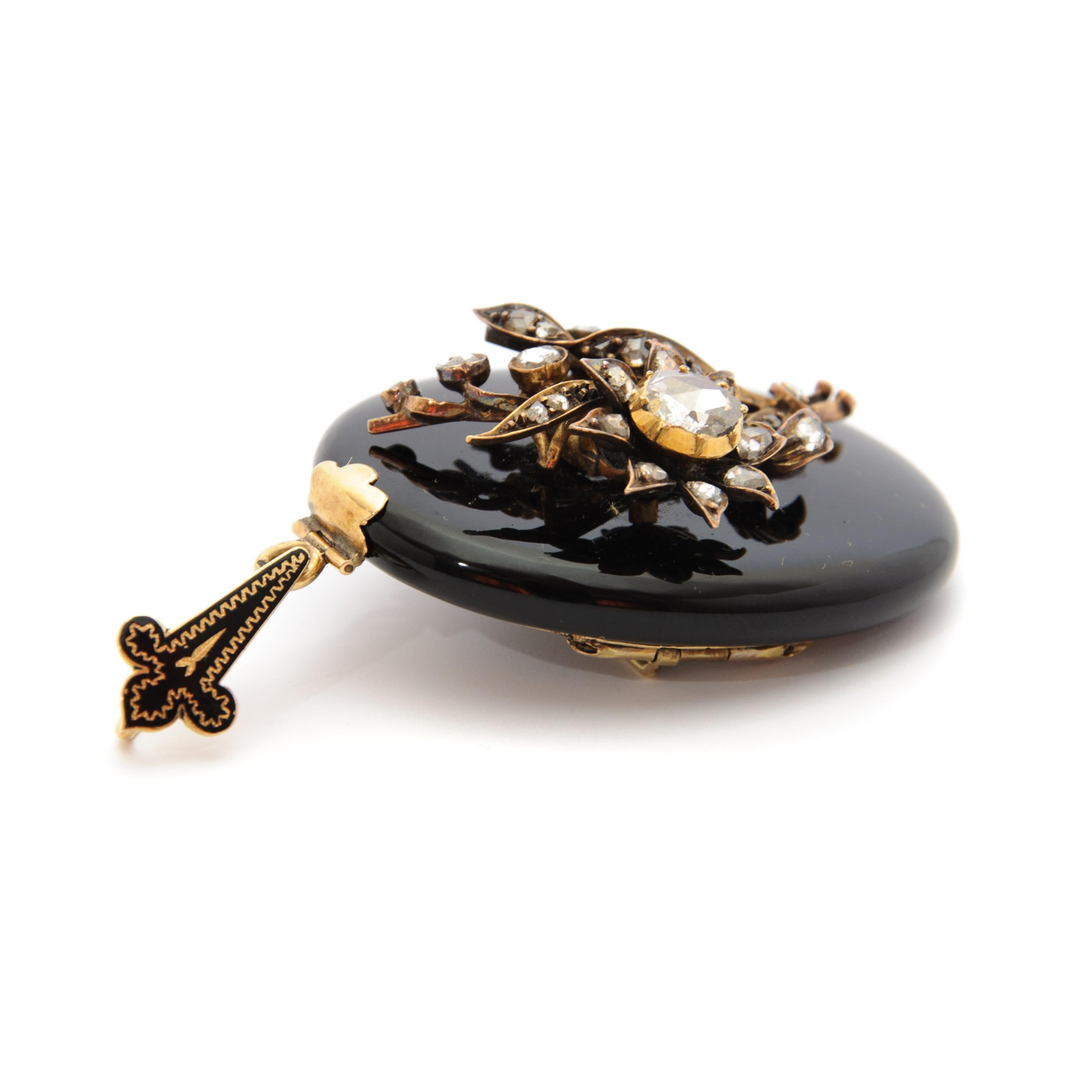 Magnificent antique onyx locket pendant brooch featuring many gorgeous diamonds. This locket pendant featuring a bouquet applique with many rose cut diamonds, approximately 0,60 carats in total. This 14 karat gold jewel can also be worn as a