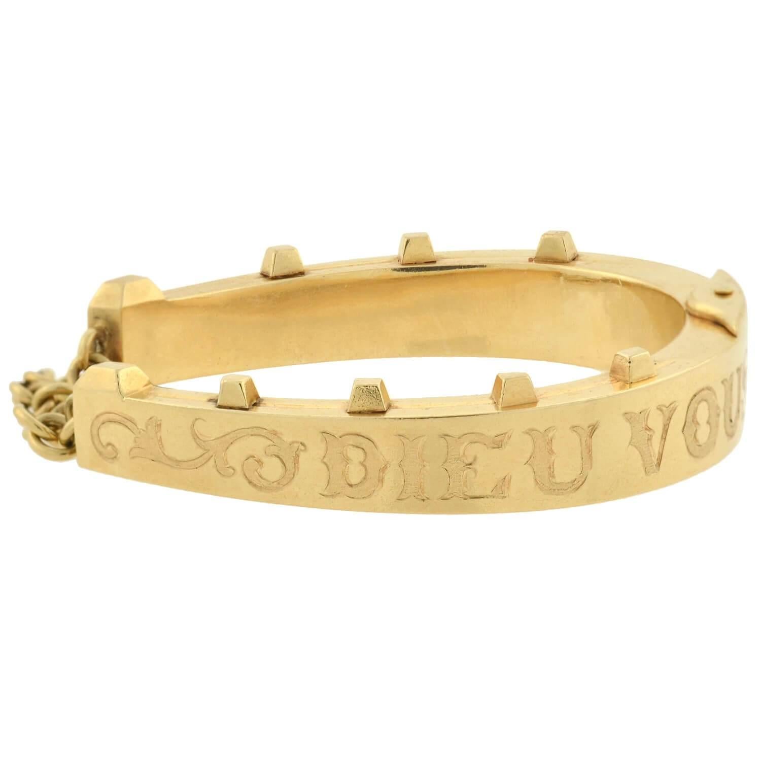 A stunning horseshoe bracelet from the Victorian (ca1880) era! Crafted in 14kt yellow gold, this hinged bangle forms the shape of a large horseshoe that wraps comfortably around the wrist. Seven raised 
