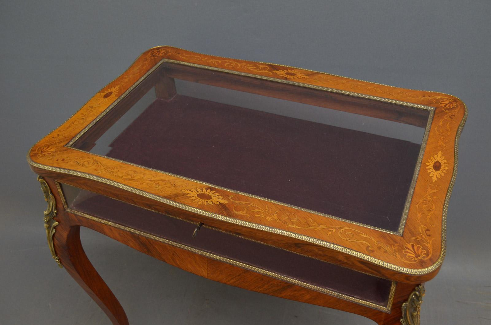 Sn4397 Truly excellent, rosewood, gilt metal mounted, display table of serpentine outline, having hinged top with original working lock and a key and bevelled edge glass plate and scrolling foliage inlays enclosing red velvet interior, all standing