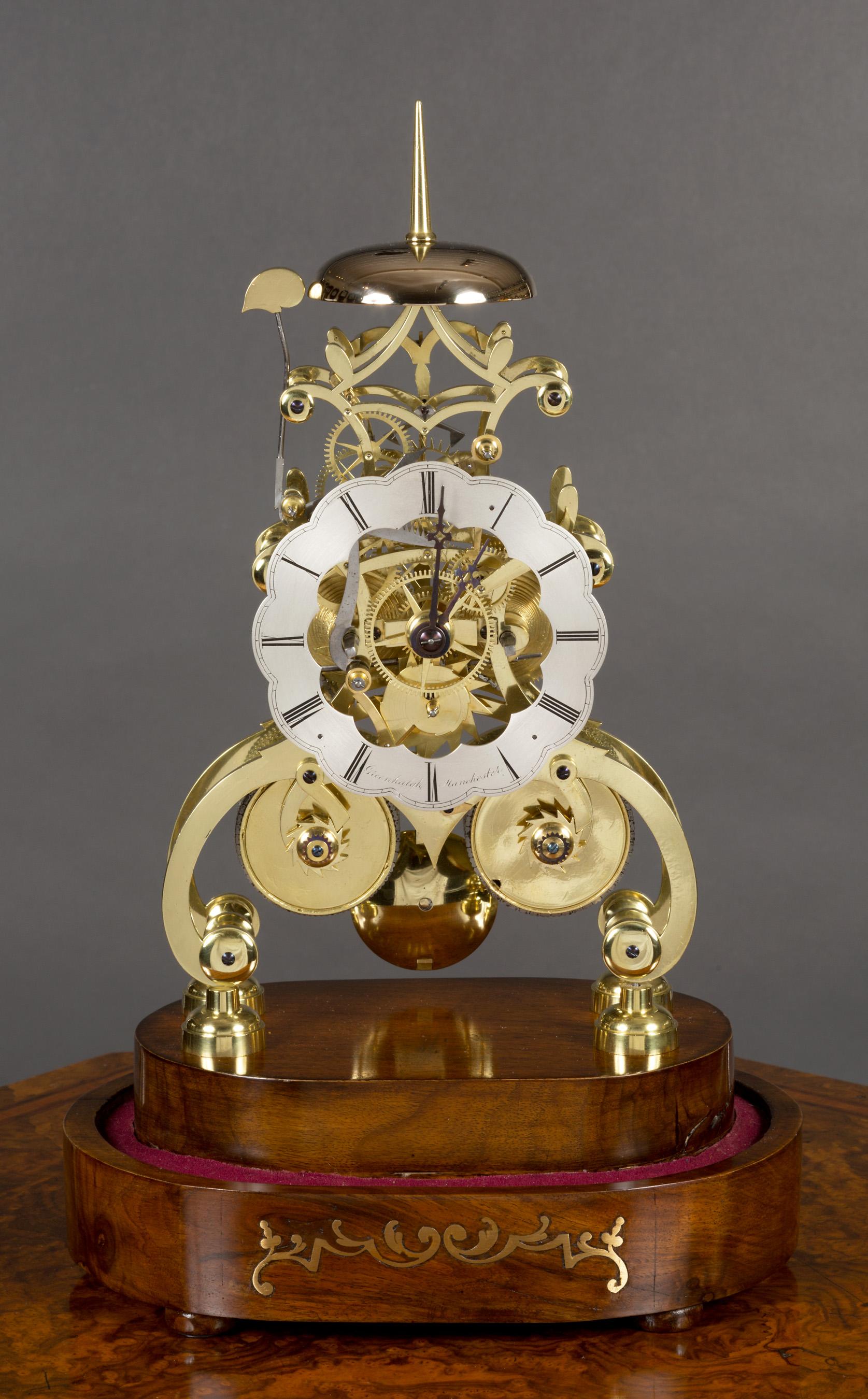 A fine Victorian striking skeleton clock.

Scroll brass frame with heavy plates and six turned, tapered pillars uniting the movement, standing on raised brass feet and resting on a stepped walnut base with brass inlay.

Scalloped, silvered dial
